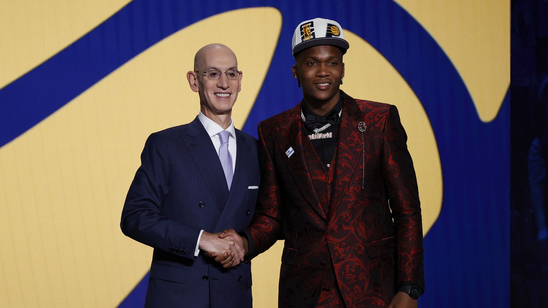 NBA commissioner shakes hands with Ben Mathurin during the draft. 