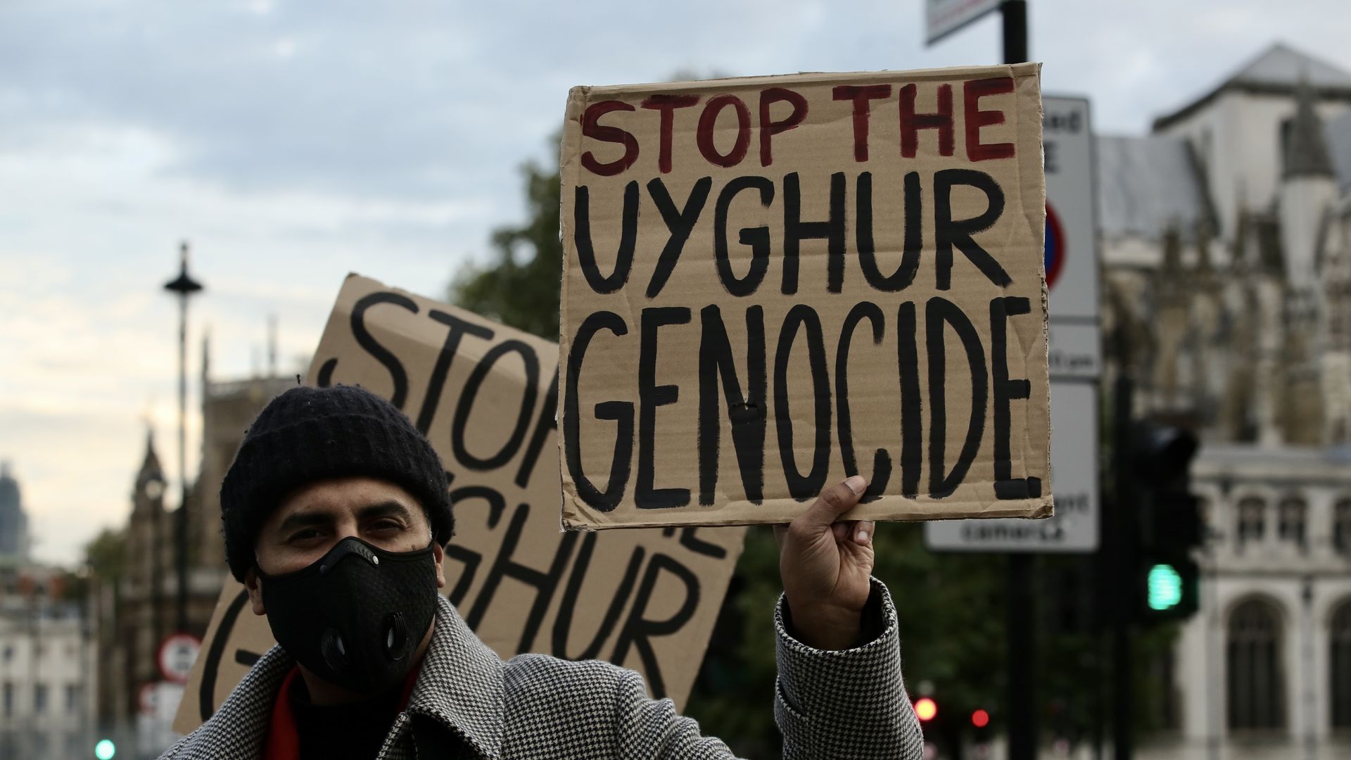 Protester holding Stop the Uyghur Genocide sign