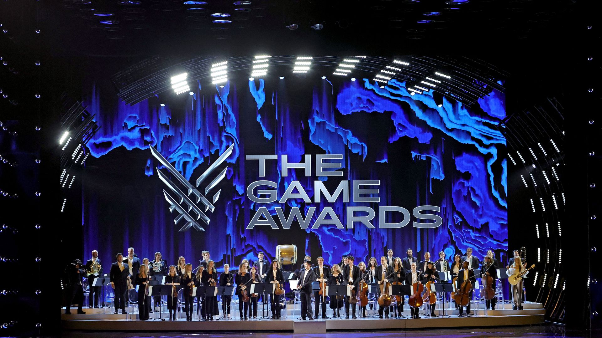 Photo of people on stage with a logo for The Game Awards in the background