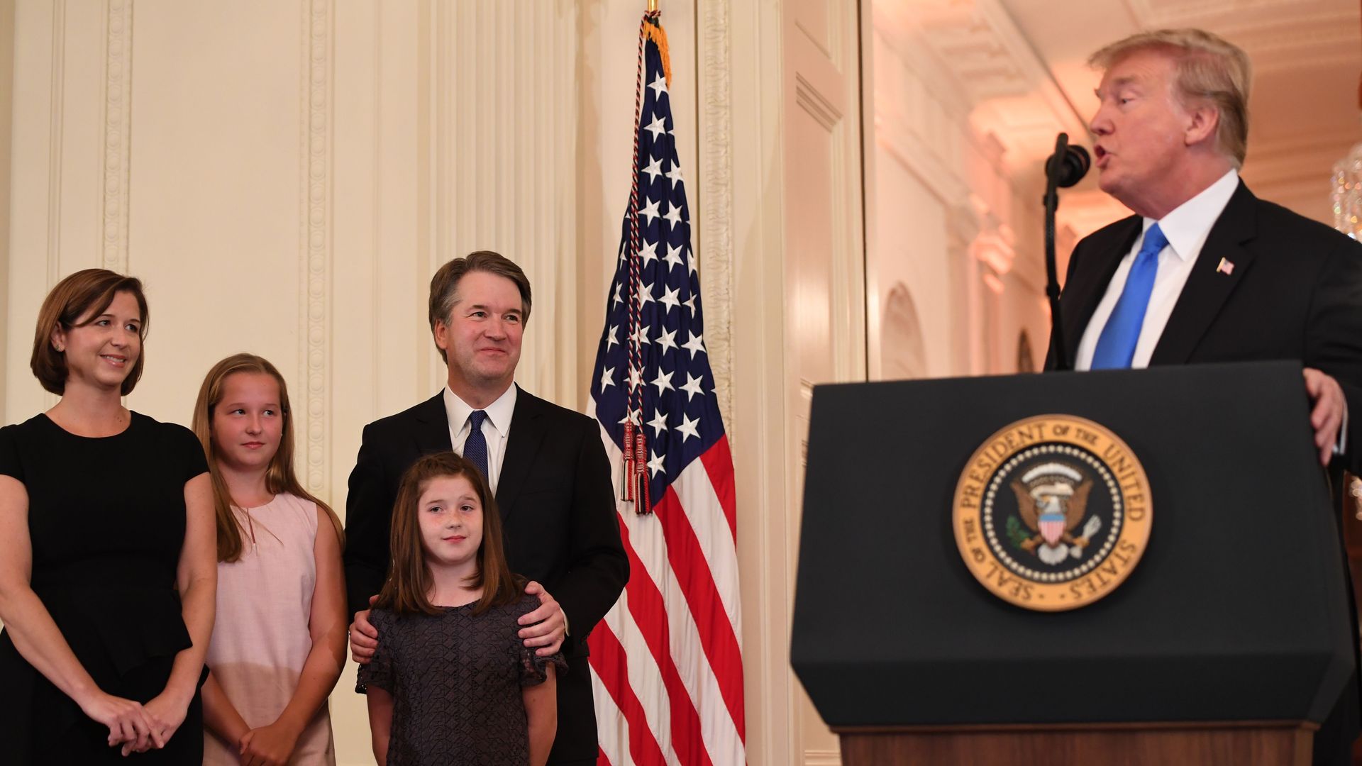 Trump looks at Brett Kavanaugh from the podium