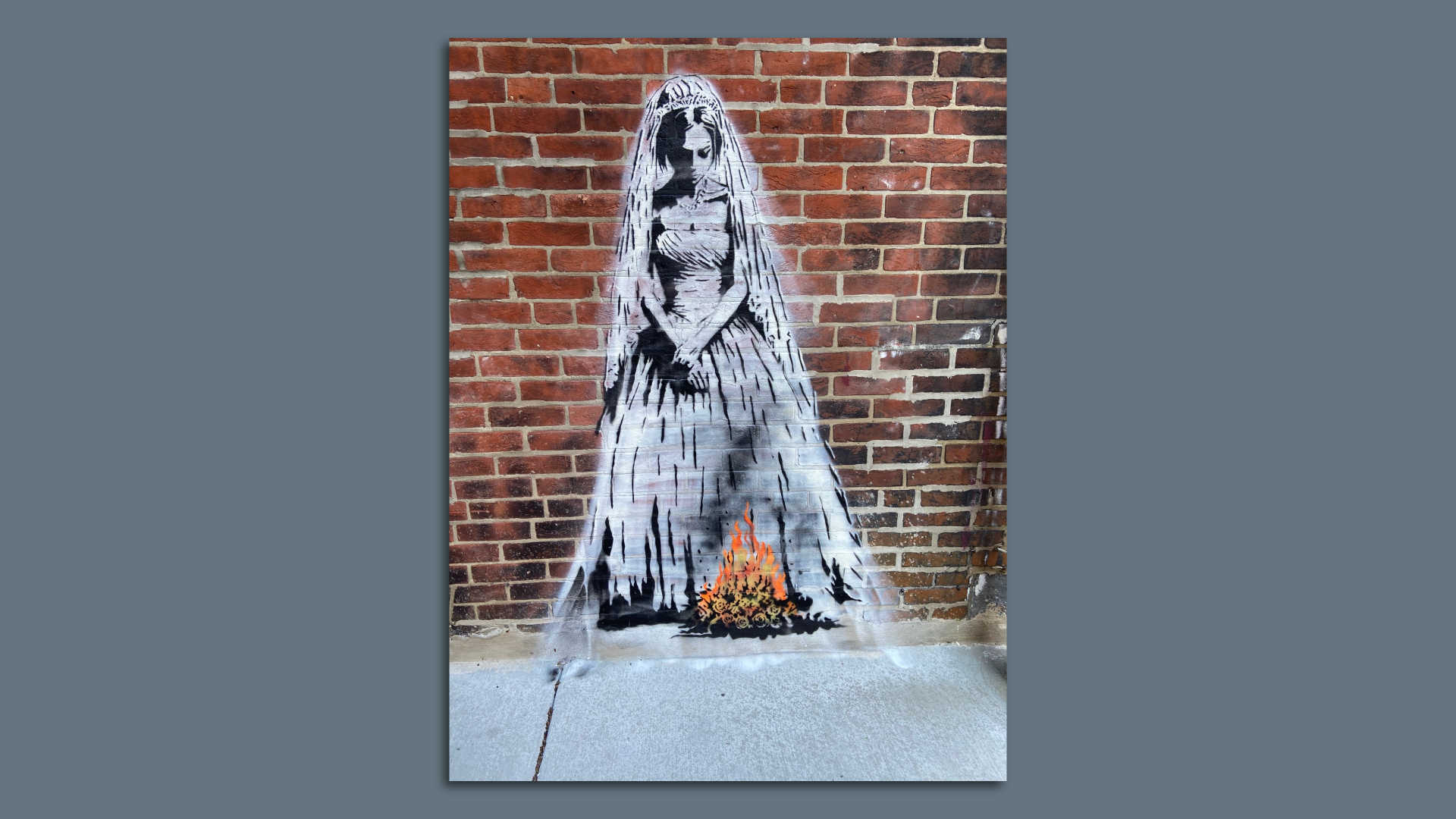 A mural of a woman in a wedding gown standing over a campfire.