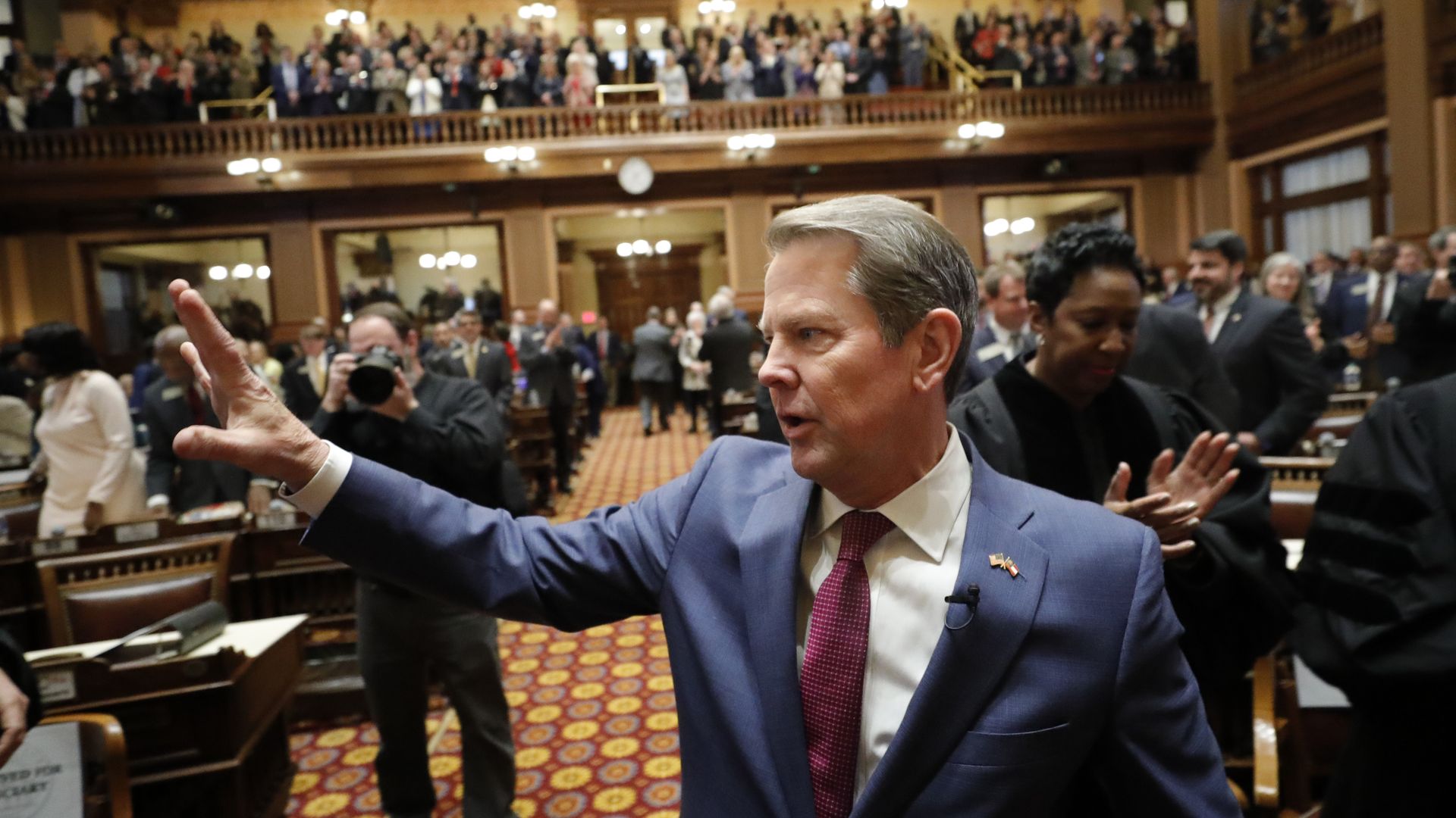 Brian Kemp waves to a crowded state House