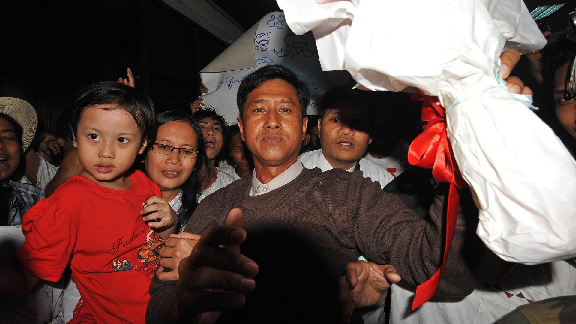 Myanmar political prisoner Kyaw Min Yu (C), known as Jimmy, and his wife holding her child upon their arrival at Yangon airport following their release from detention on January 13, 2012. 