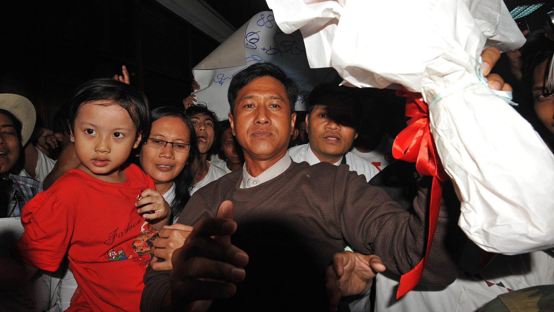 Myanmar political prisoner Kyaw Min Yu (C), known as Jimmy, and his wife holding her child upon their arrival at Yangon airport following their release from detention on January 13, 2012.