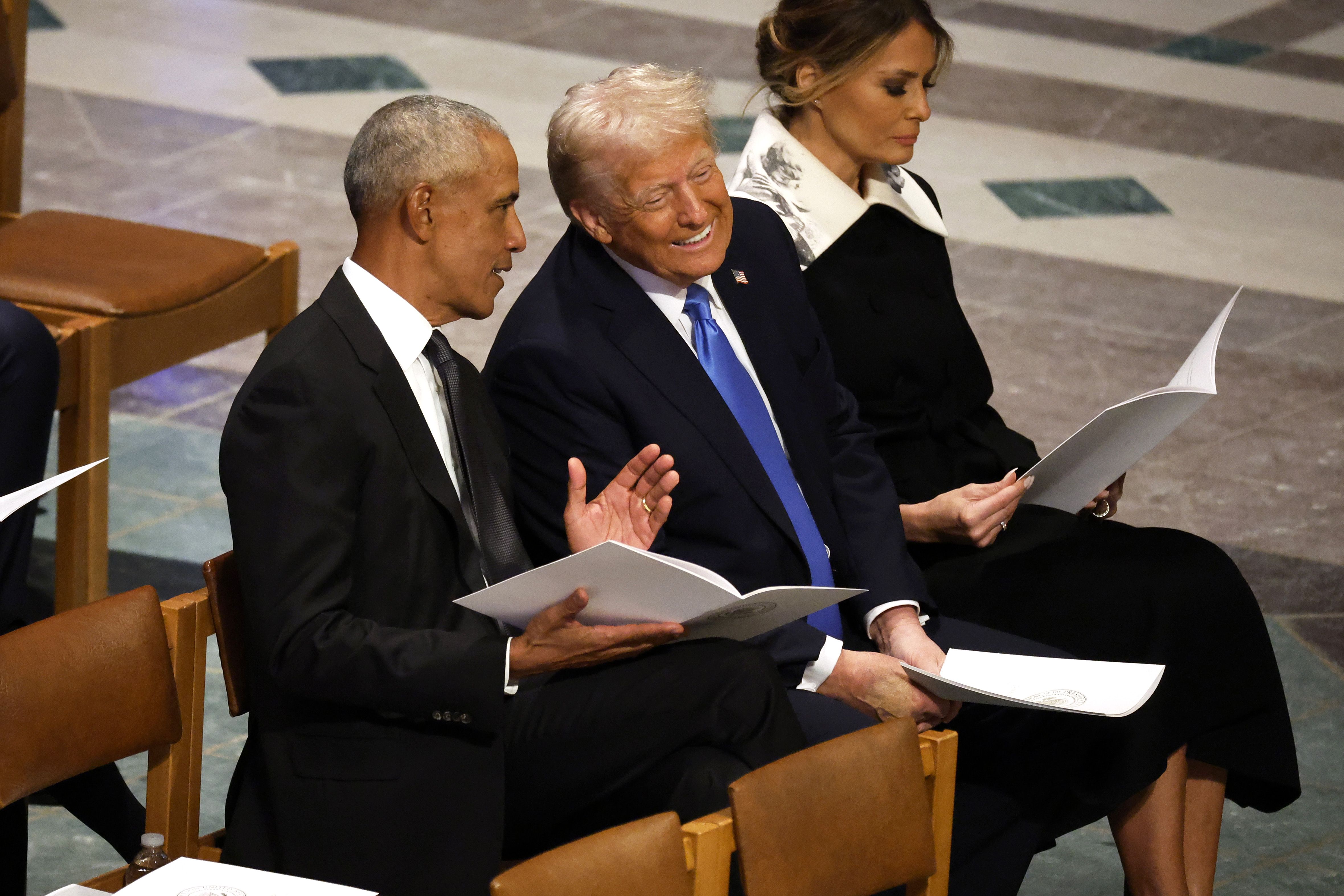 WASHINGTON, DC - JANUARY 09: U.S. President-elect Donald Trump speaks with former U.S. President Barack Obama as Melania Trump looks on during the state funeral for former U.S. President Jimmy Carter at Washington National Cathedral on January 09, 2025 in Washington, DC. President Joe Biden declared