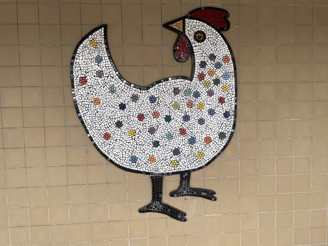 A mural of a chicken with colorful dots on the animal's body.