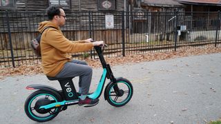 Nue Villanueva trys out Veo's seated scooter on the Razorback Regional Greenway in Fayetteville on Saturday. 