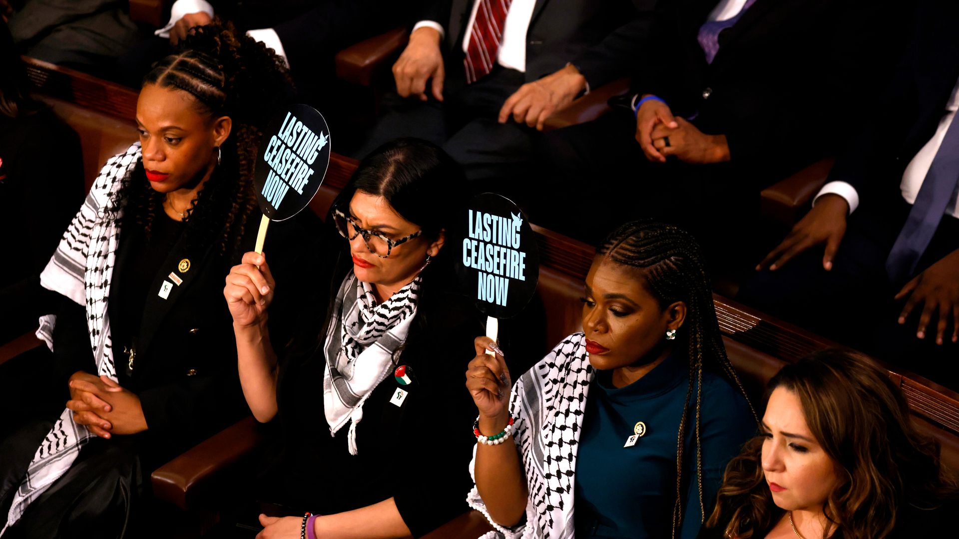 Representative Rashida Tlaib, a Democrat from Michigan, center, and Representative Cori Bush, a Democrat from Missouri, center right, hold up signs calling for a ceasefire during a State of the Union address at the US Capitol in Washington, DC, US, on Thursday, March 7, 2024.