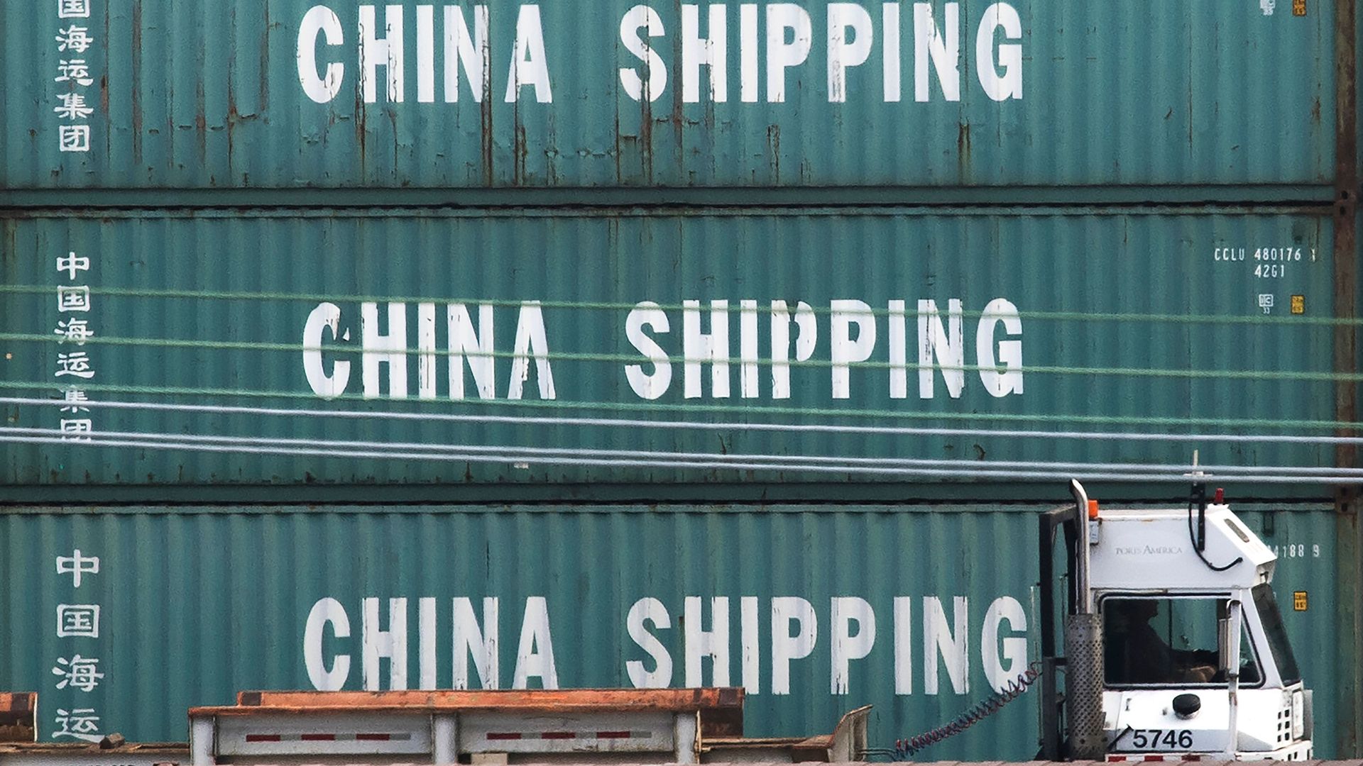 A truck passes by China Shipping containers at the Port of Los Angeles