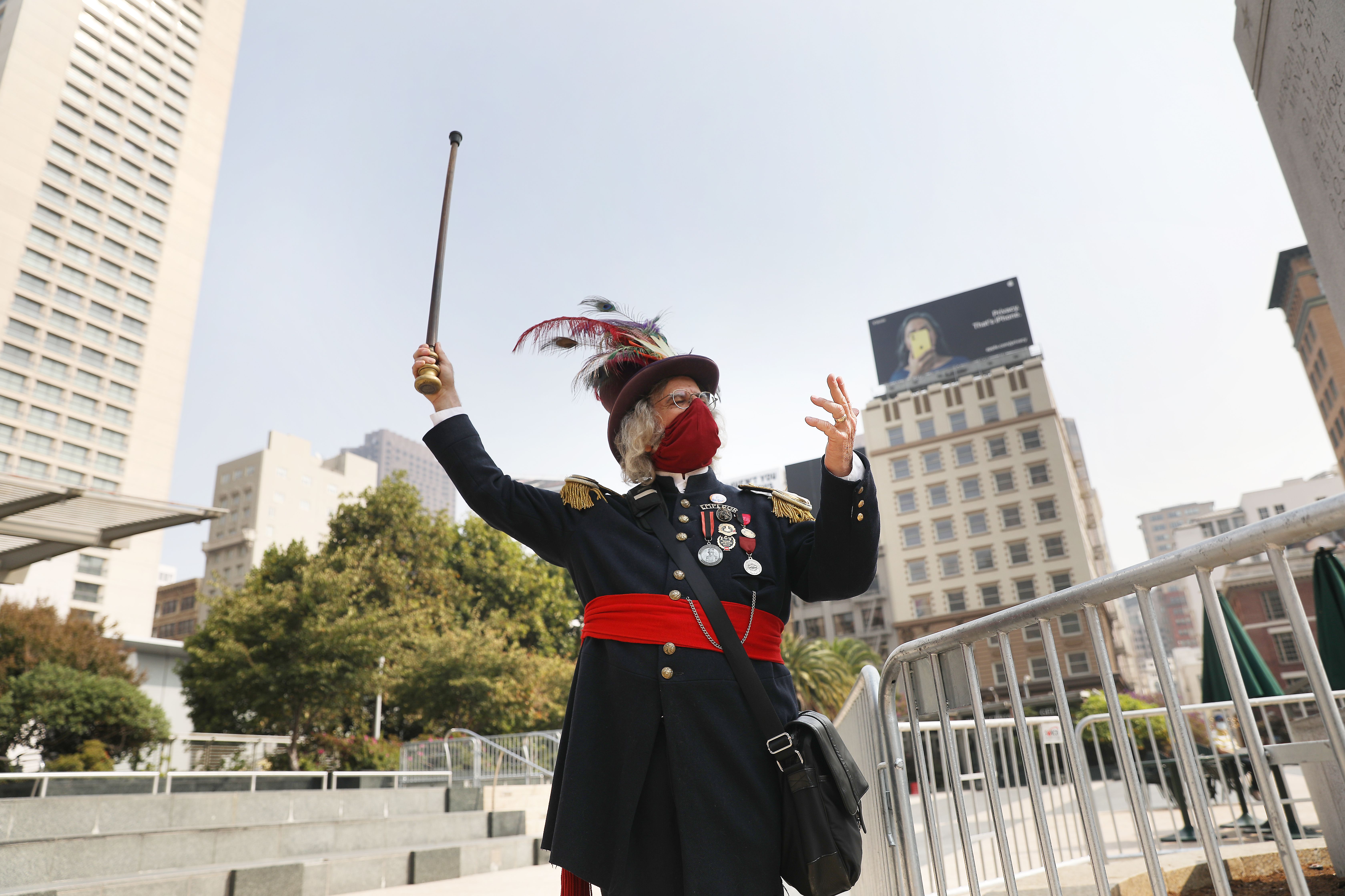 Photo of an Emperor Norton impersonator, dressed in full regalia and waving a walking stick