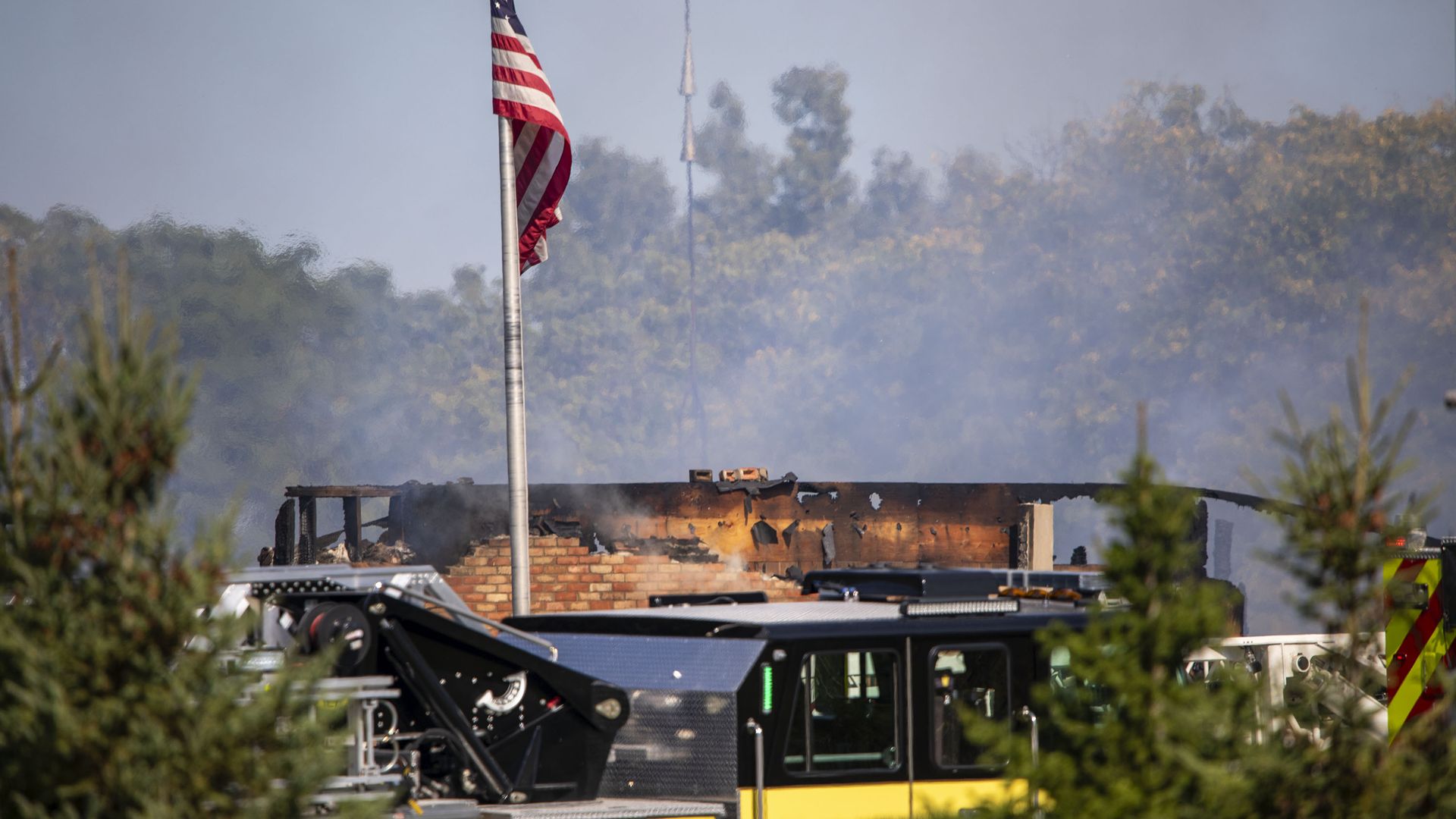 The remains of a church building after a fire, with a US flag flying above it. 