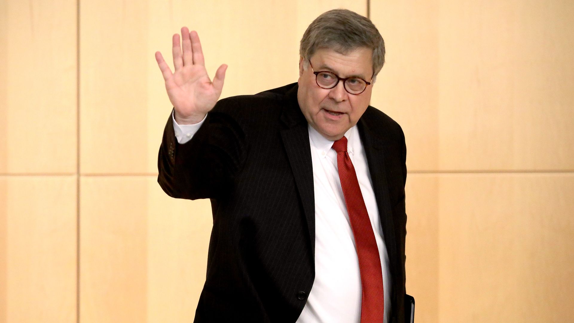 Attorney General William Barr waves to someone outside the shot.