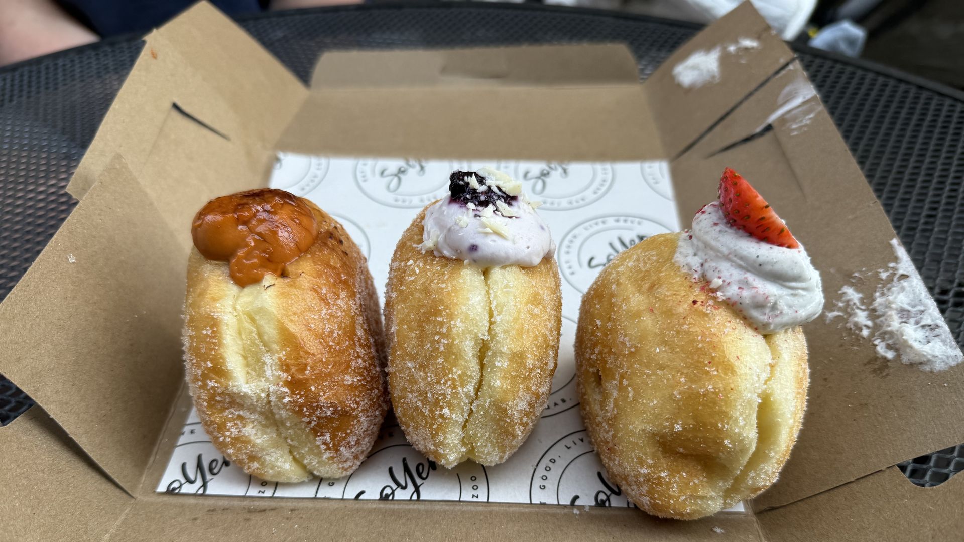 three donuts with cream coming out the top