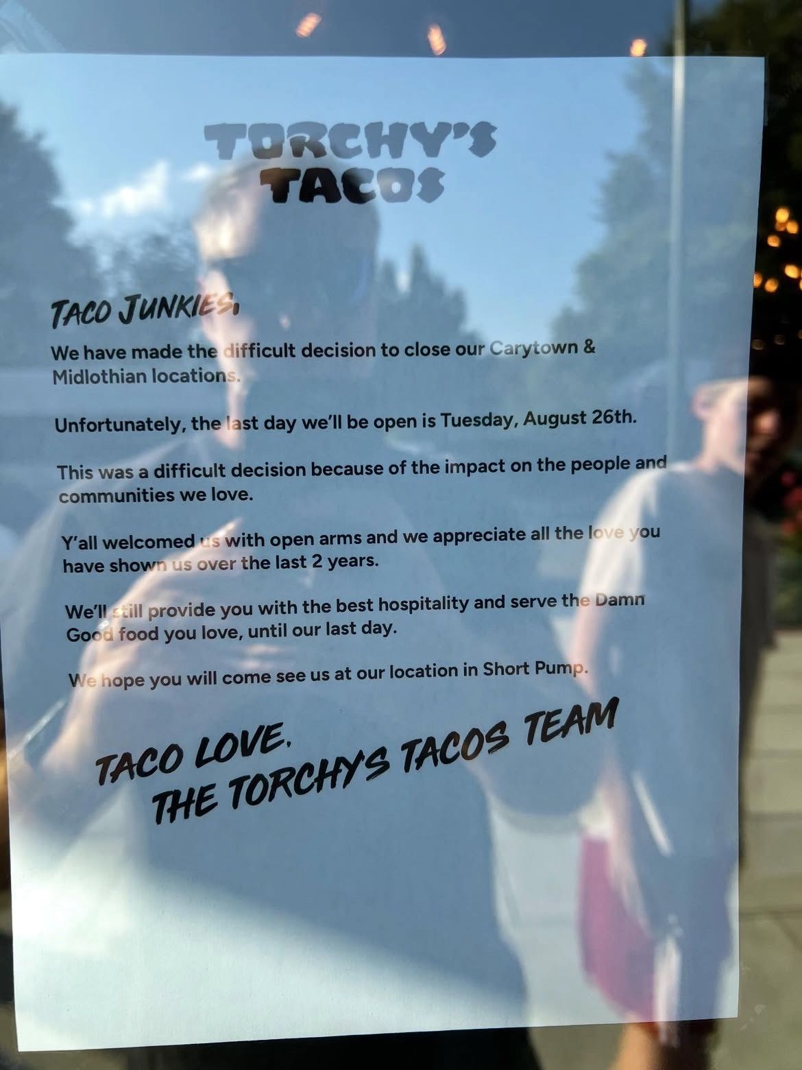 A sign on the door of a Torchy's Tacos saying Midlo and Carytown will close 