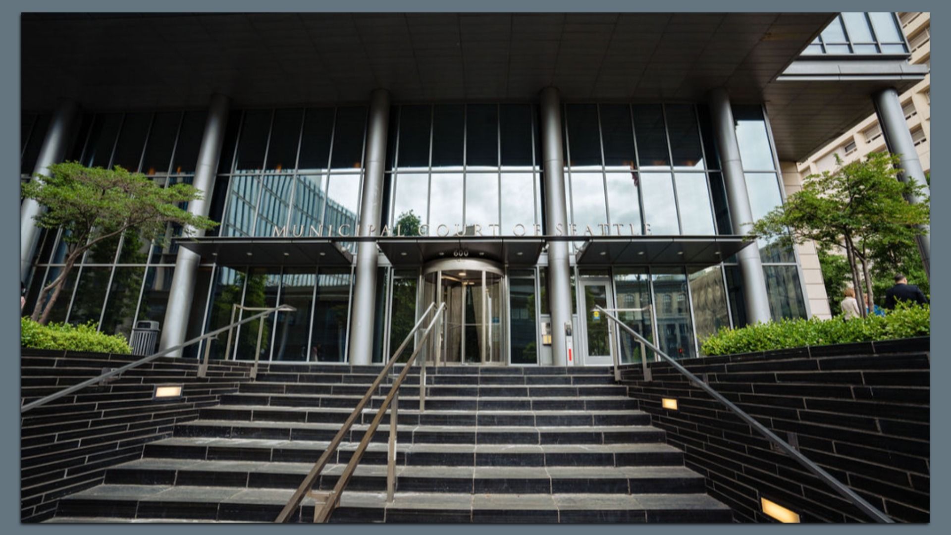 A photo of the steps leading to a sleek glass building that says "Municipal Court of Seattle." 