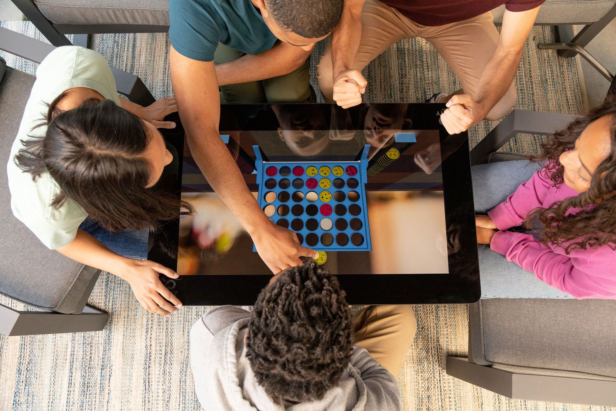 A family plays Connect 4 on the Infinity Game Table. 