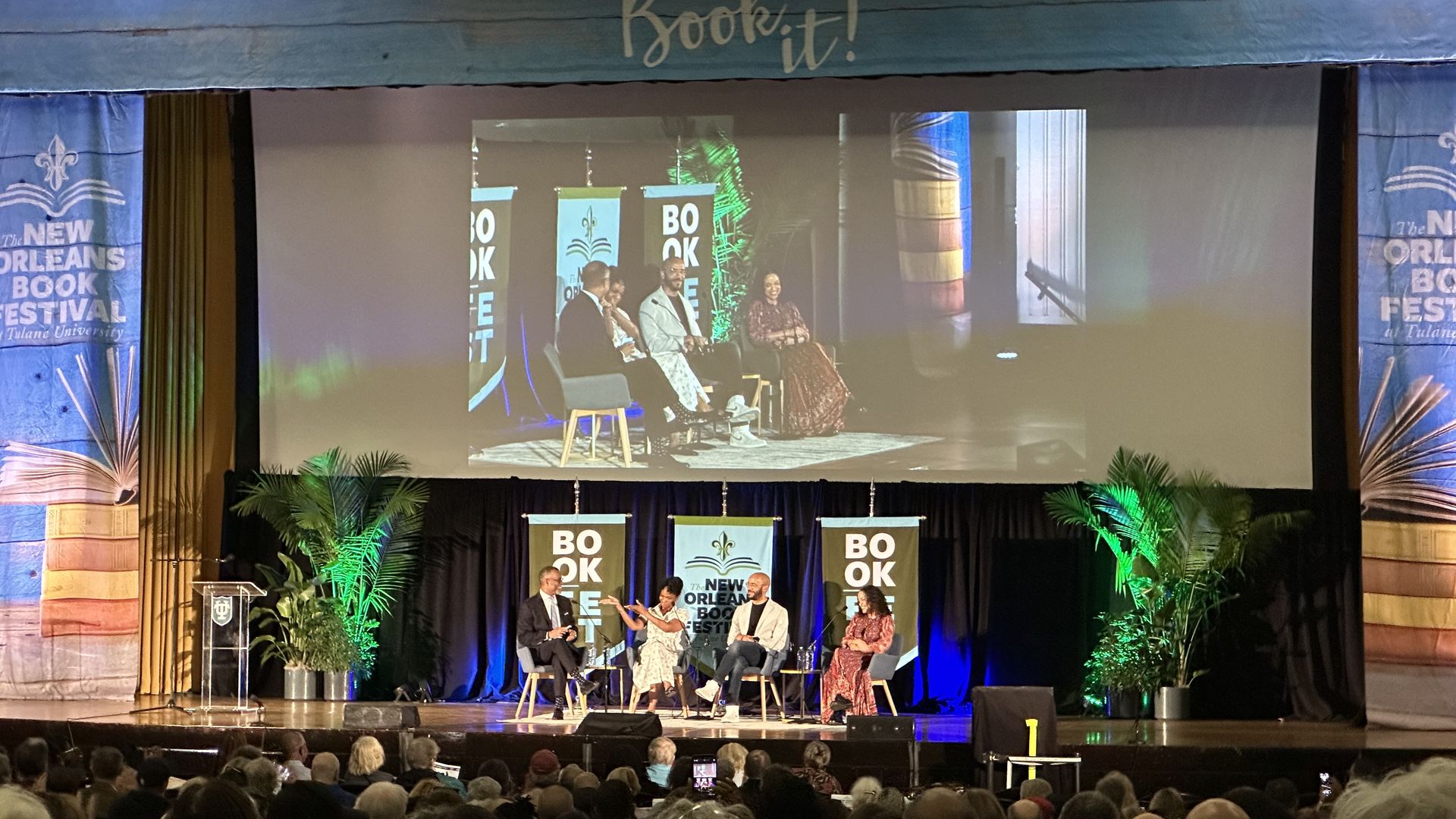 Four people sit onstage during a panel discussion.
