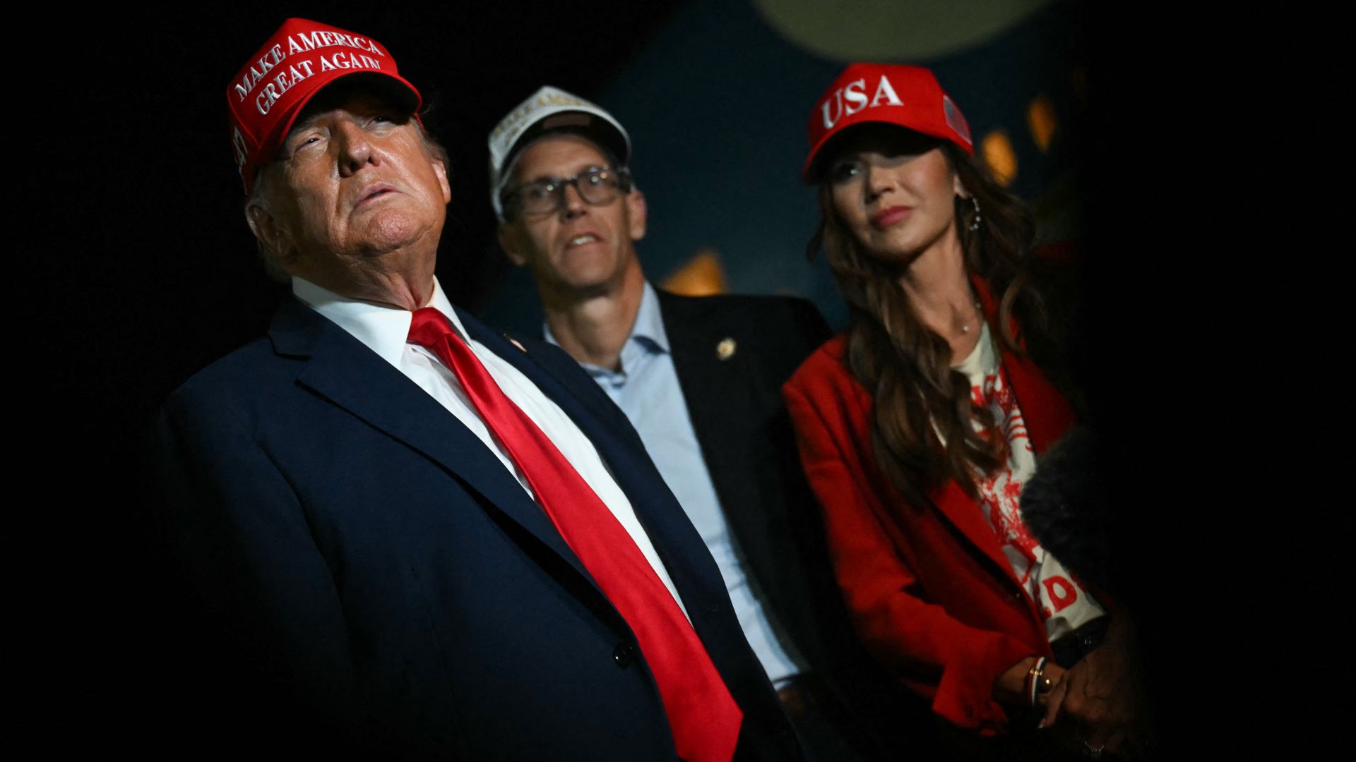 S Secretary of Homeland Security Kristi Noem (R) watches US President Donald Trump talk to journalists as they arrive at Joint Base Andrews, Maryland early on July 4, 2025.