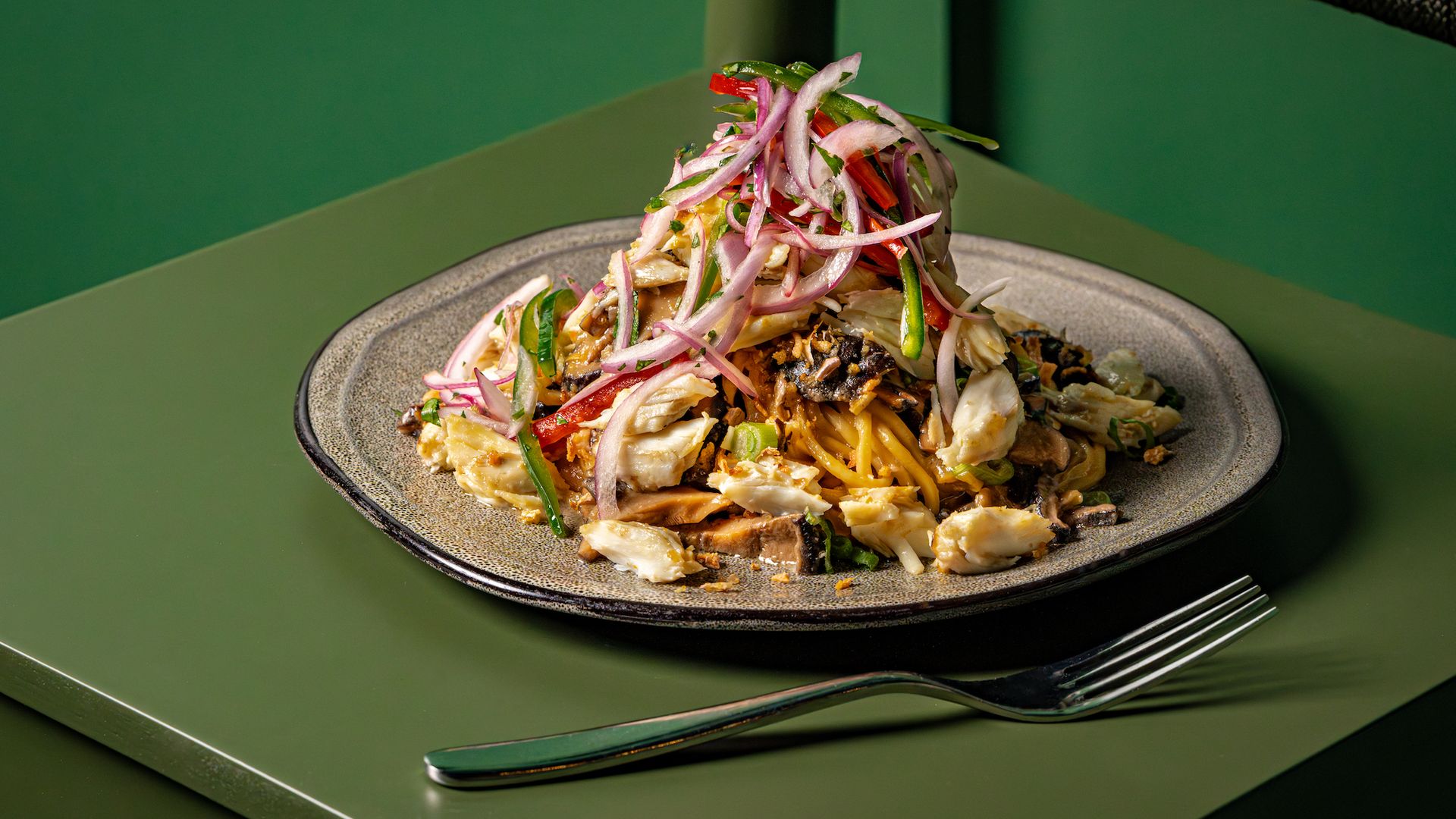 Maryland crab lo mein topped with a onion-pepper salad