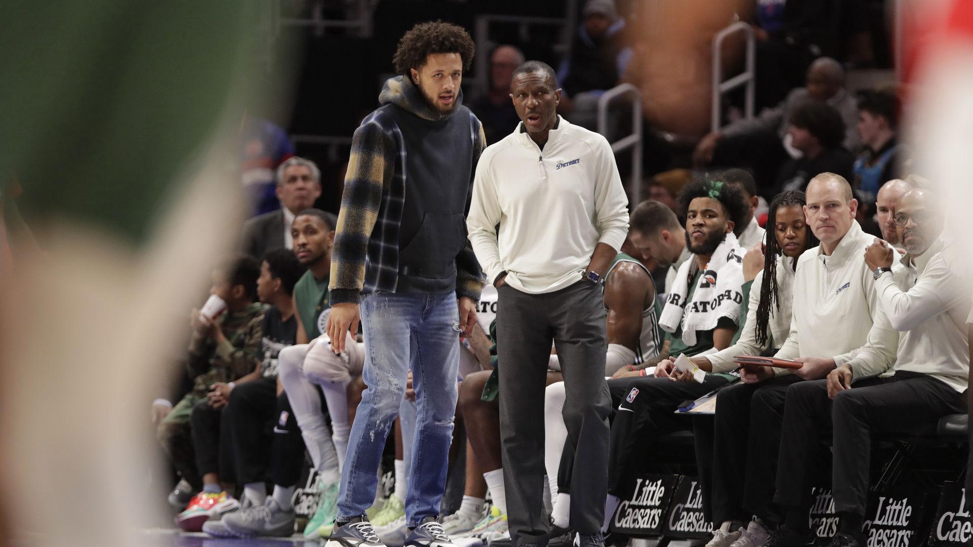 Cade Cunningham and Dwane Casey converse on the sideline.