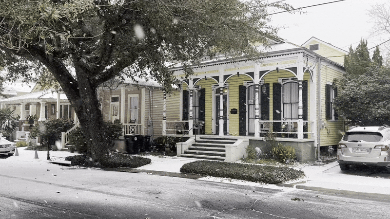 Snow falls in front of a New Orleans shotgun house.