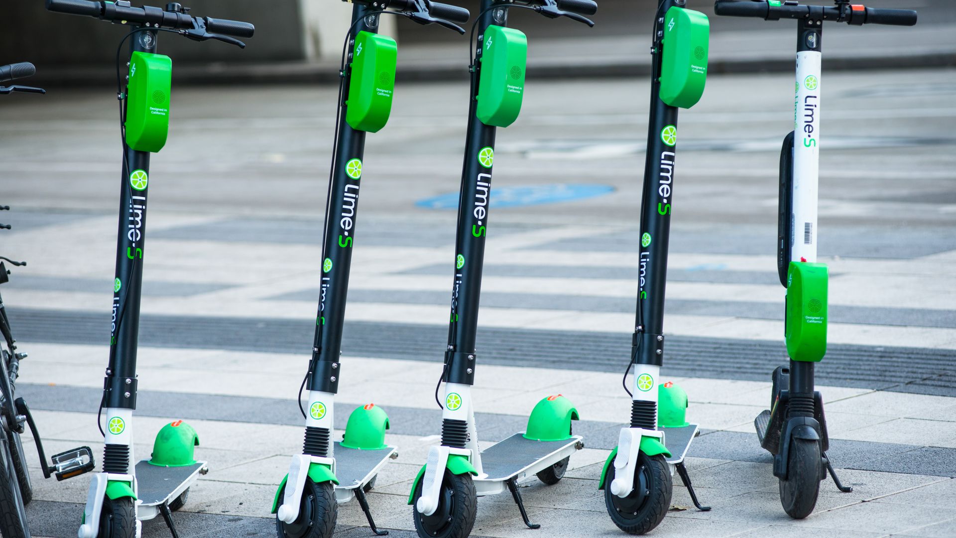 A group of Lime scooters lined up.