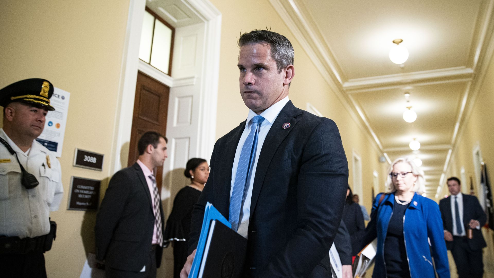 Photo of Adam Kinzinger walking in a Capitol hallway