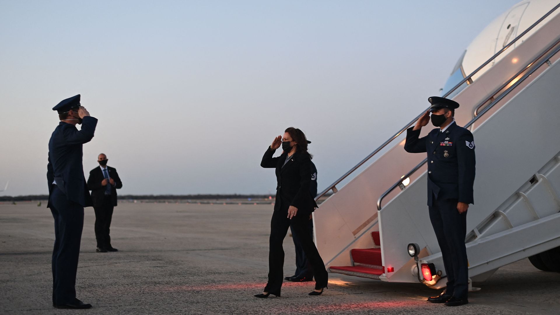 Vice President Kamala Harris is seen saluting as she steps off Air Force Two.