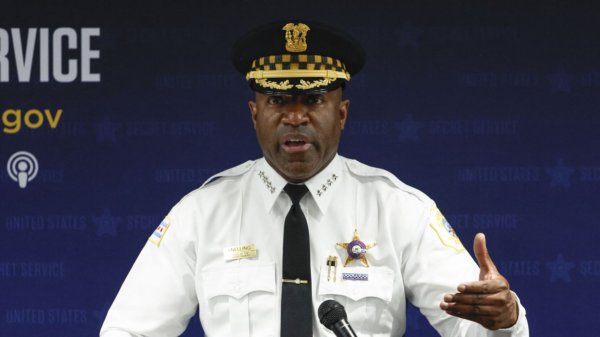 Photo of a police commander behind a podium talking. 