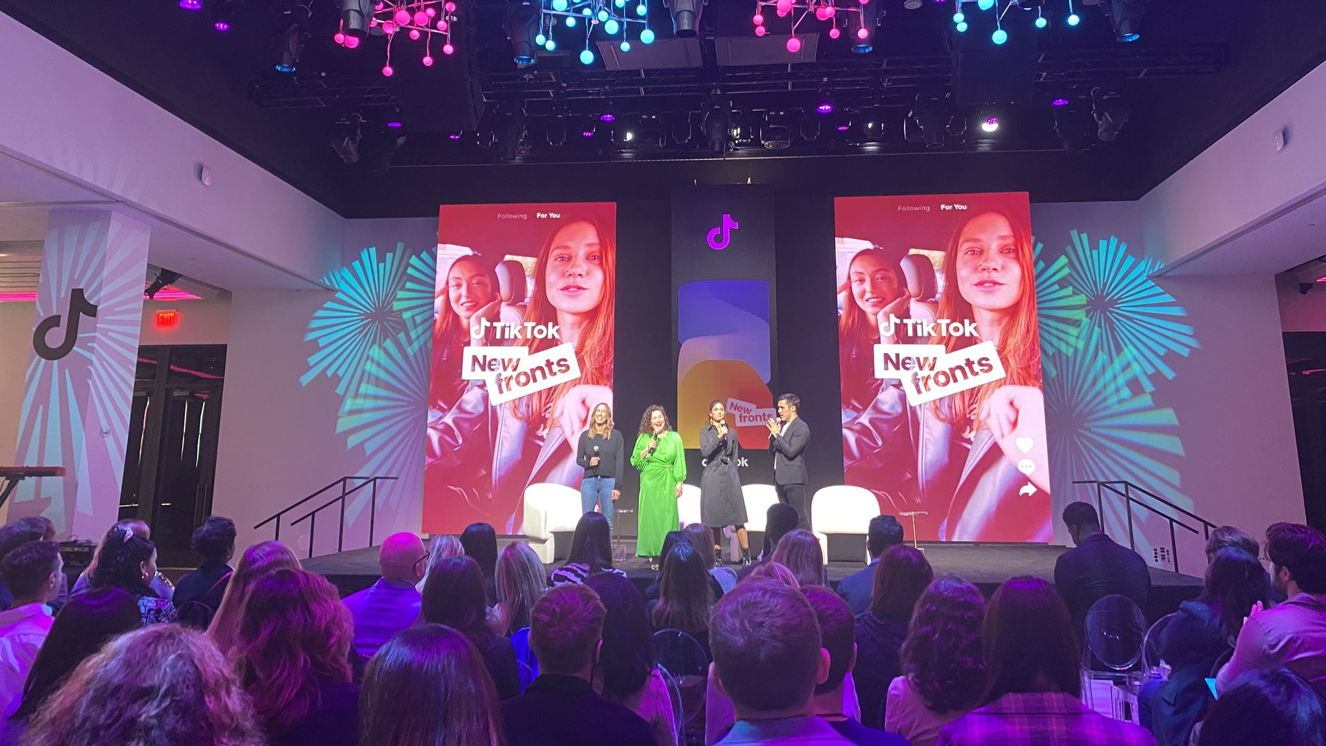 Photo from TikTok's NewFronts presentation, audience looking at four people standing onstage