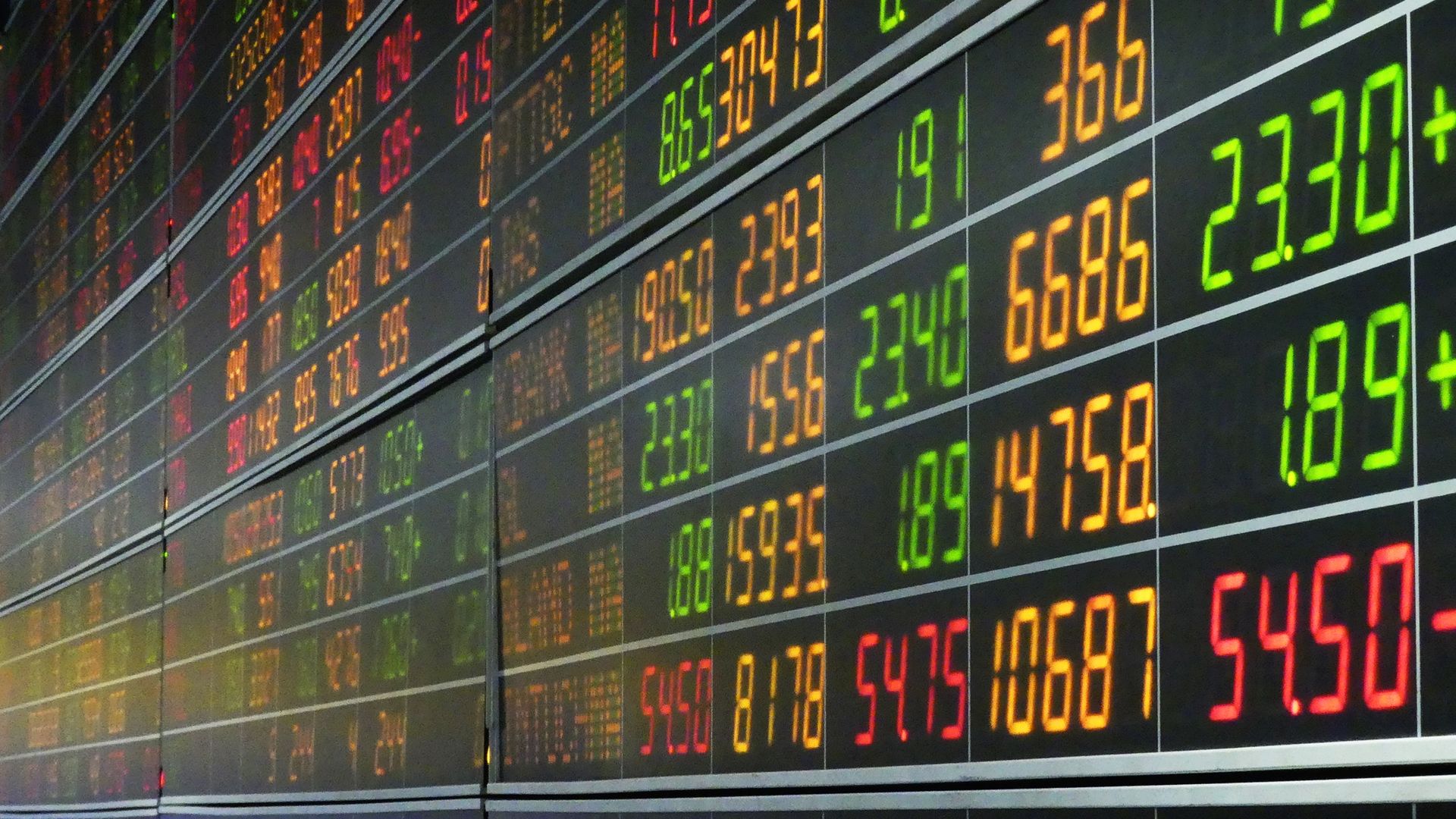 In this image, green, orange and red stock numbers are displayed on a screen. 