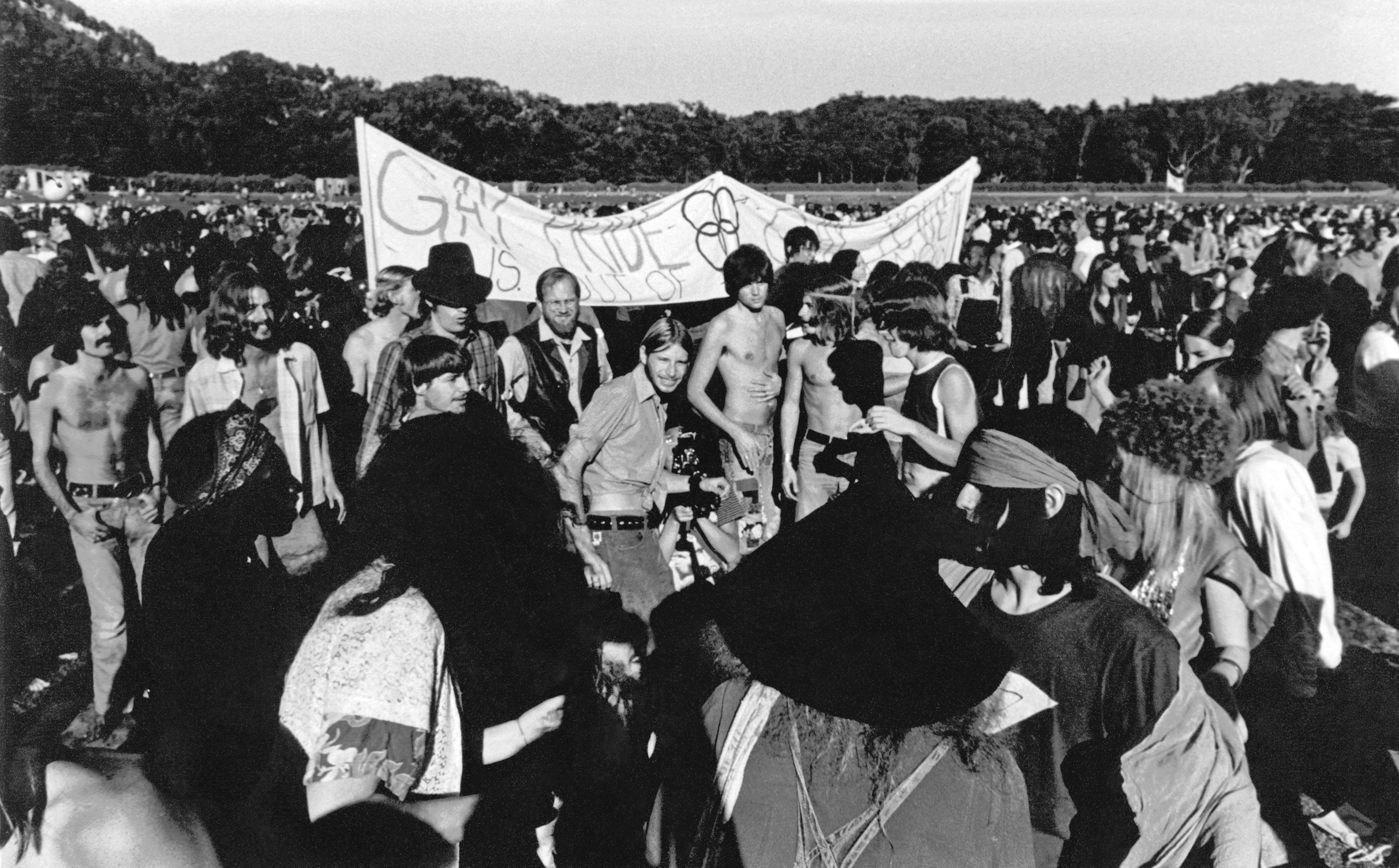 Photo of people gathered with a sign that says "Gay Pride"