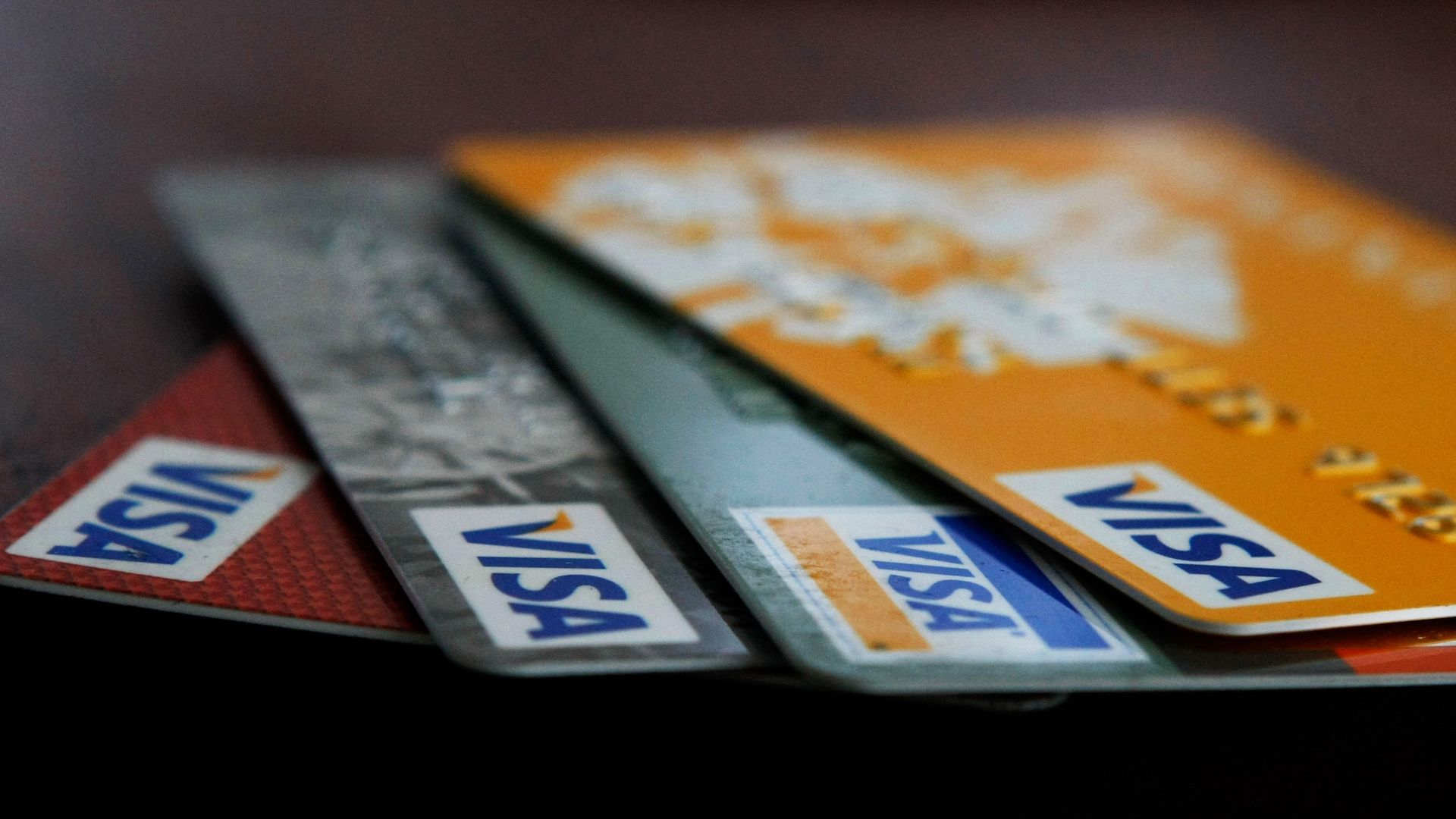 Visa credit cards are arranged on a desk