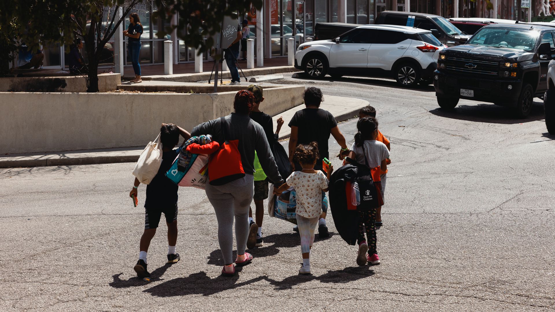 A groups of migrants walk from the Migrant Resource Center to a nearby shopping center.