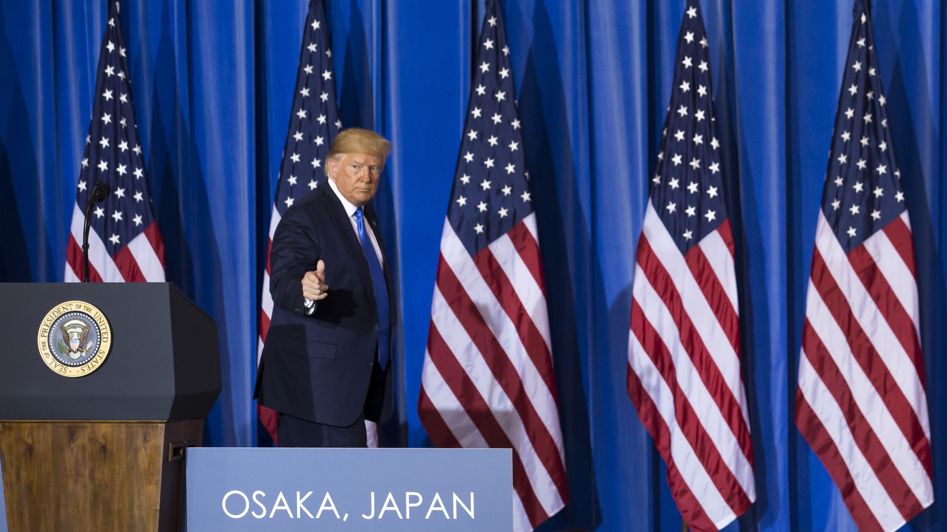 President Trump on stage after a press conference in Japan.