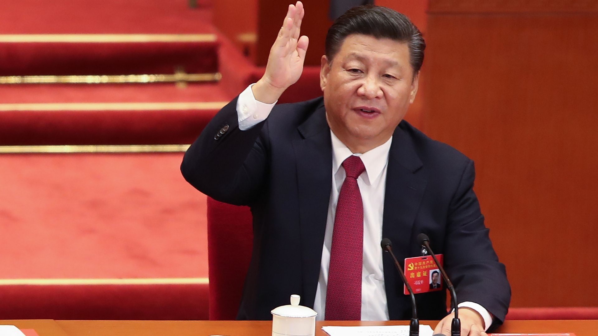 Chinese President Xi Jinping raises his hand