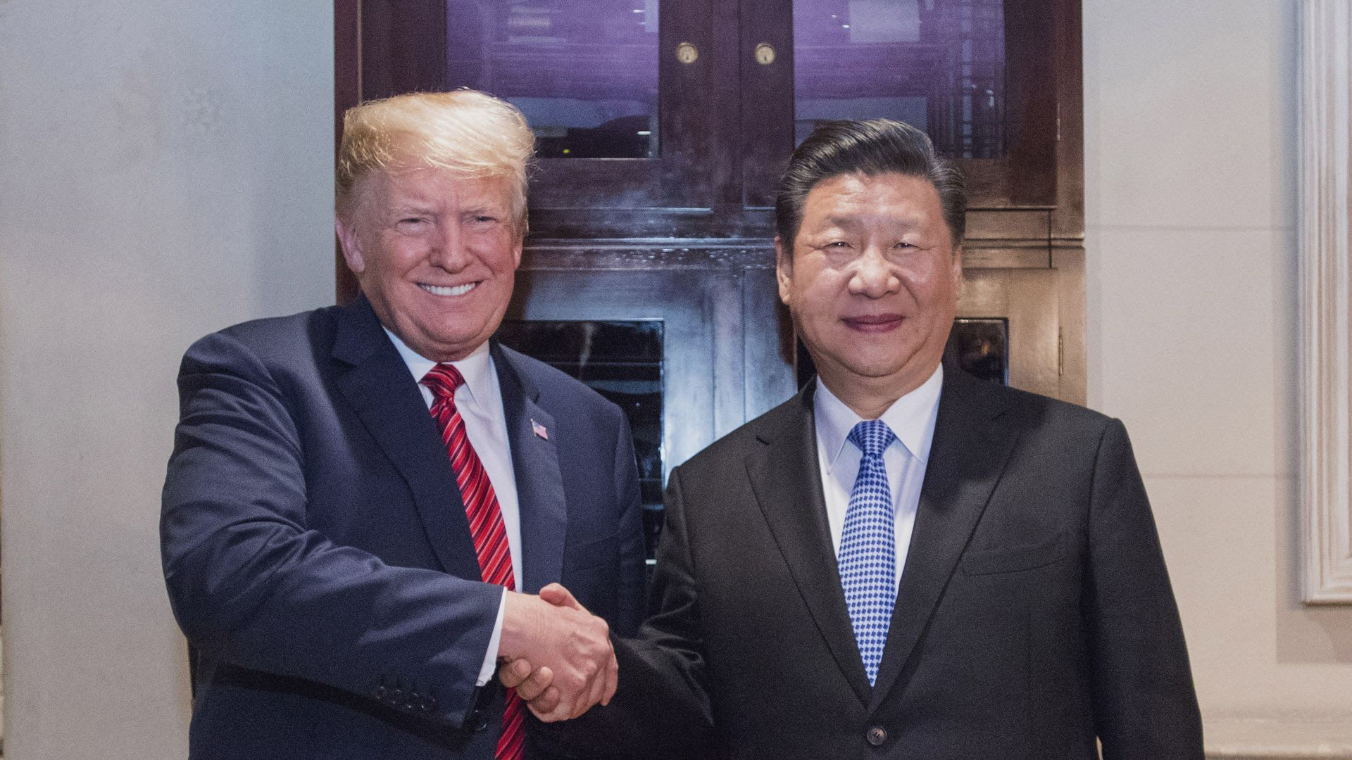 President Trump and Chinese President Xi Jinping smile while shaking hands 