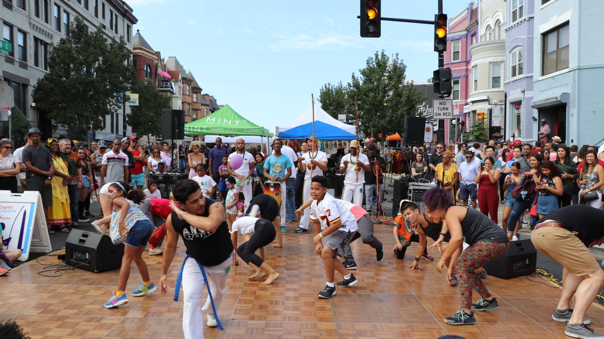 People dancing in the street to celebrate Adams Morgan Day.