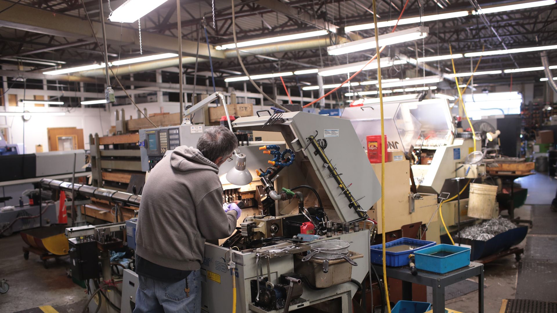 Worker operates a Swiss screw machine also known at an automated lathe at Makerite Manufacturing on October 07 2019 in Roscoe Illinois