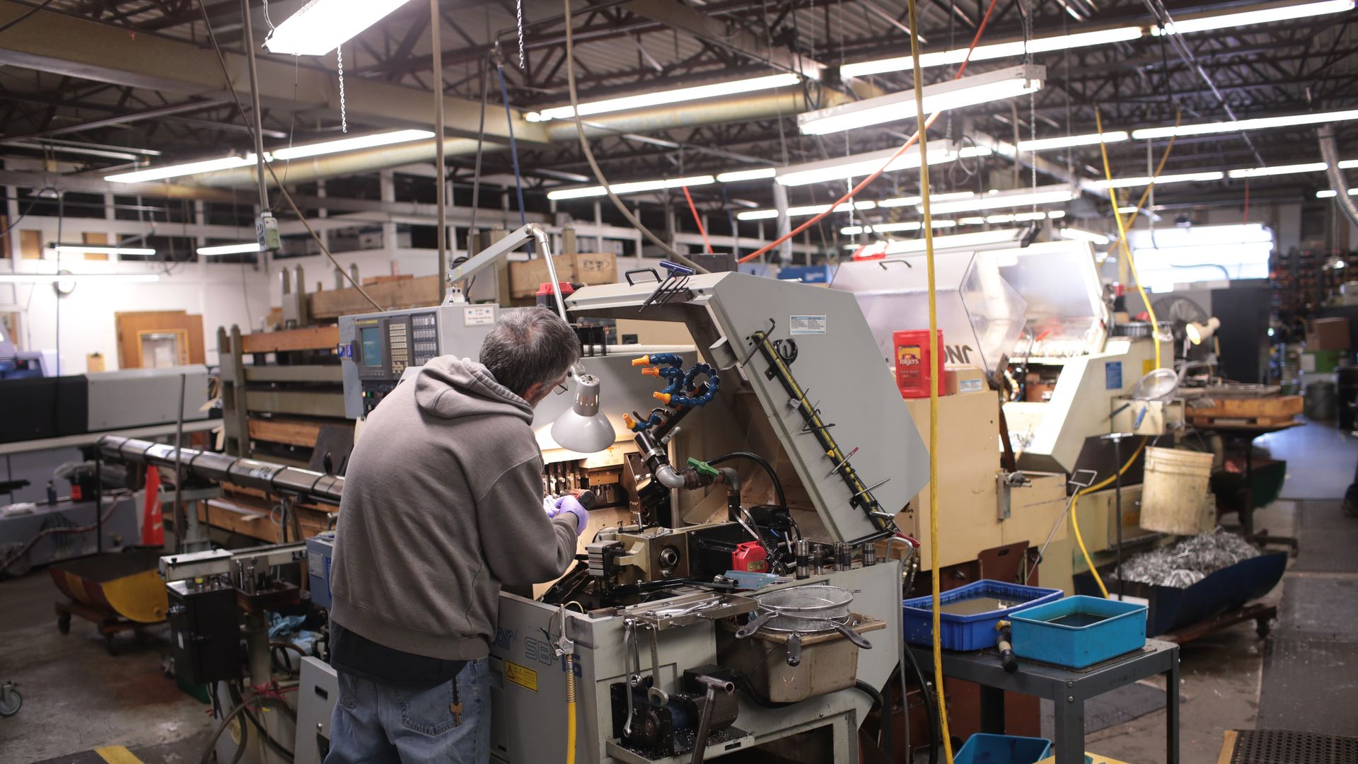 Worker operates a Swiss screw machine (also known at an automated lathe) at Makerite Manufacturing on October 07, 2019 in Roscoe, Illinois