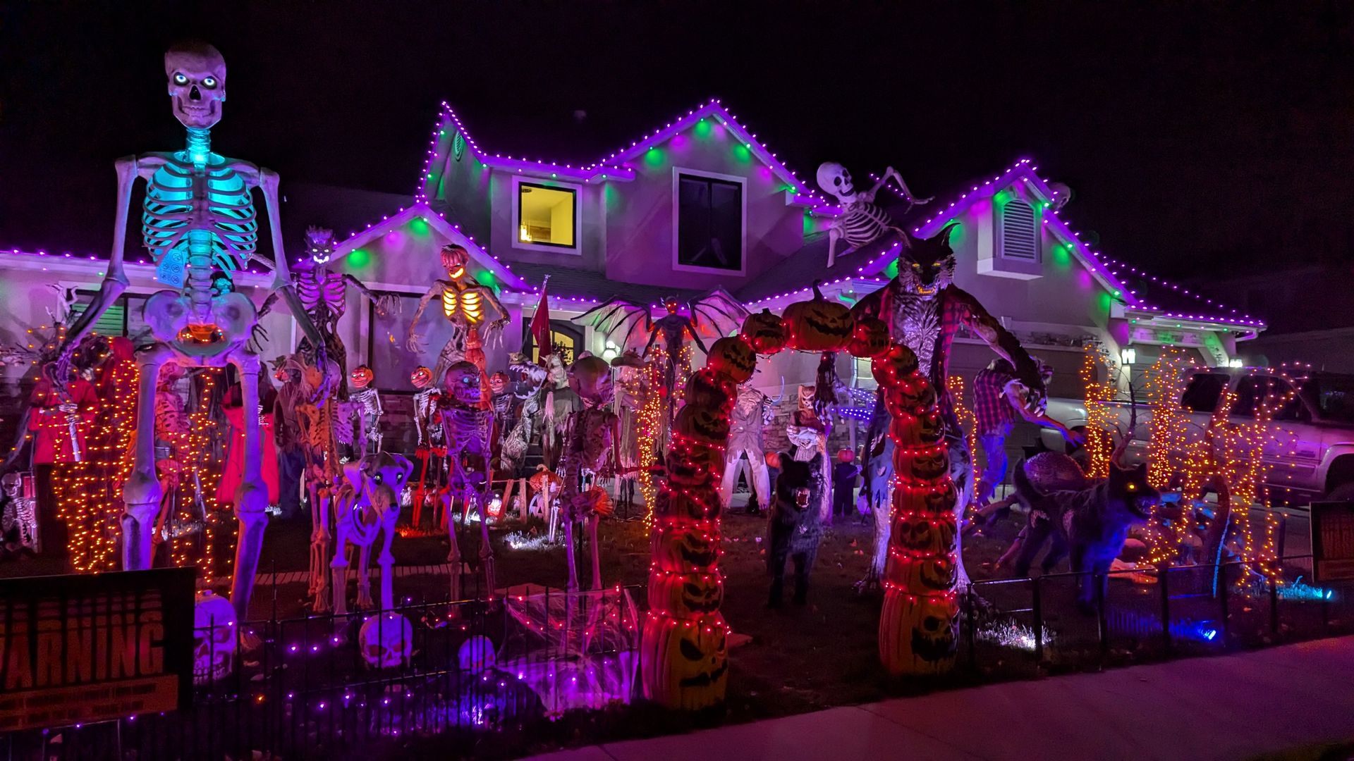 A house with numerous halloween decorations in the front yard.