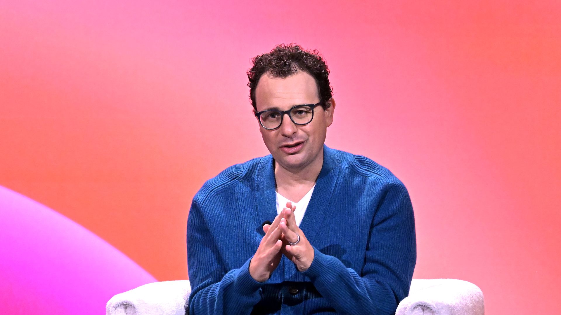 Dario Amodei sitting in a chair on stage