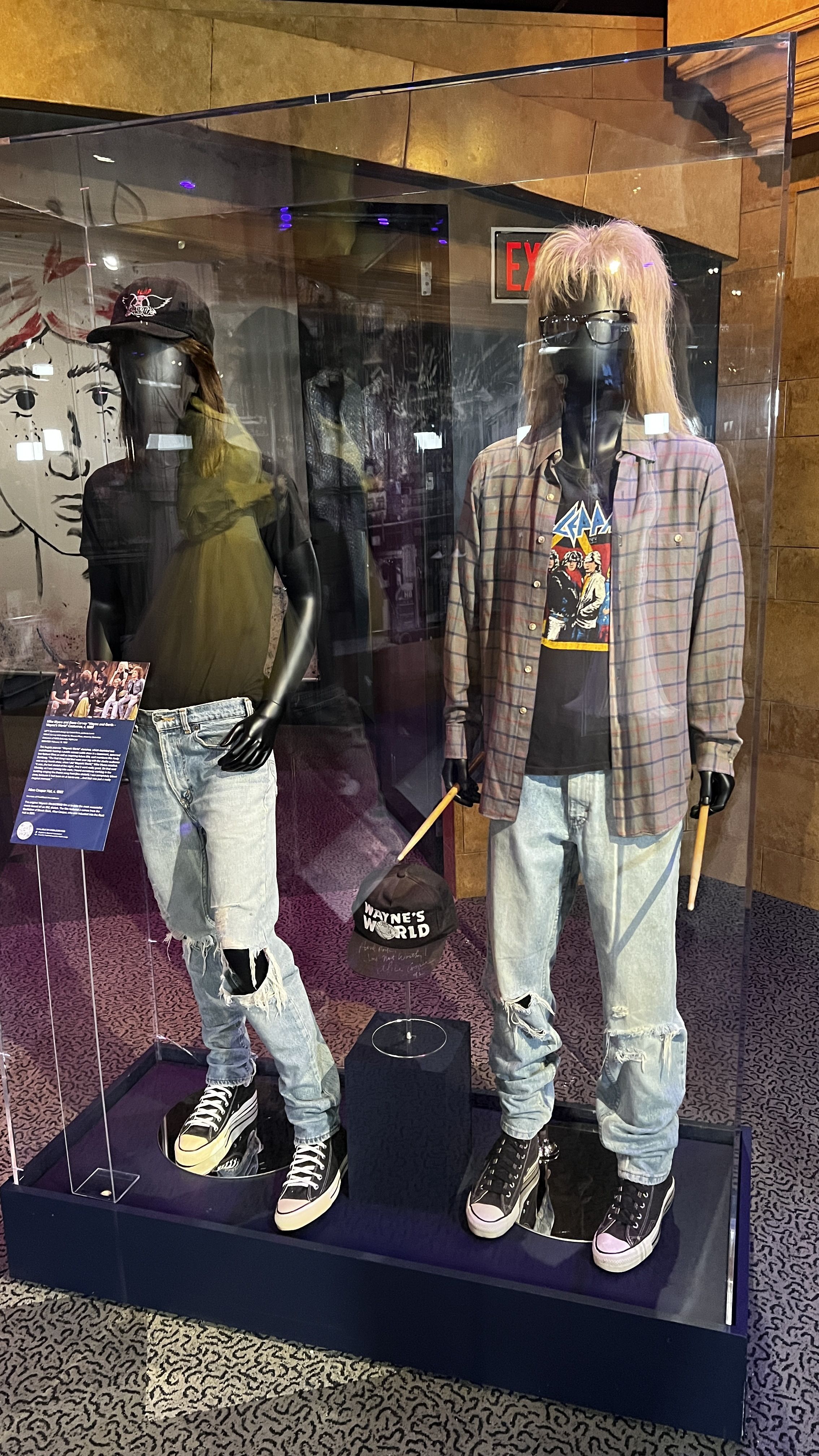 The costumes worn during "Wayne's World" in a glass showroom case. 