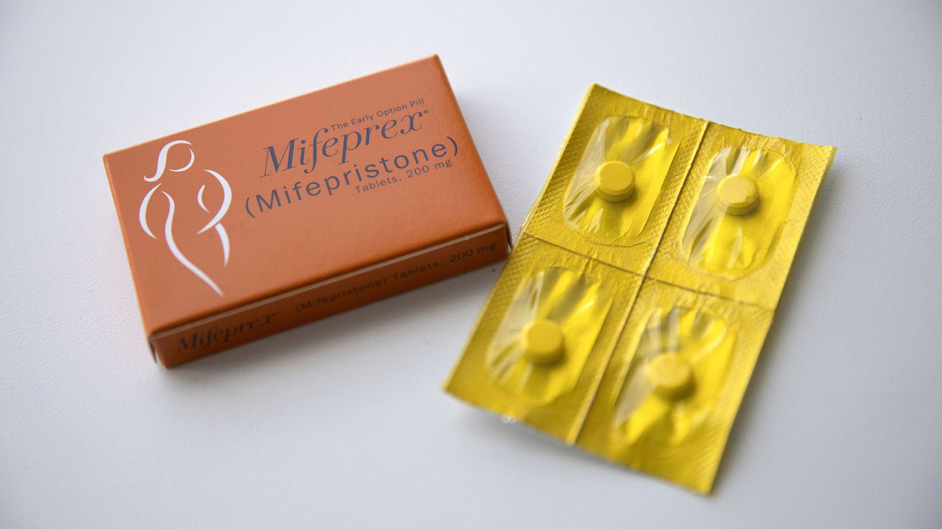 Photo of a set of pills lying next to a box of Mifeprex