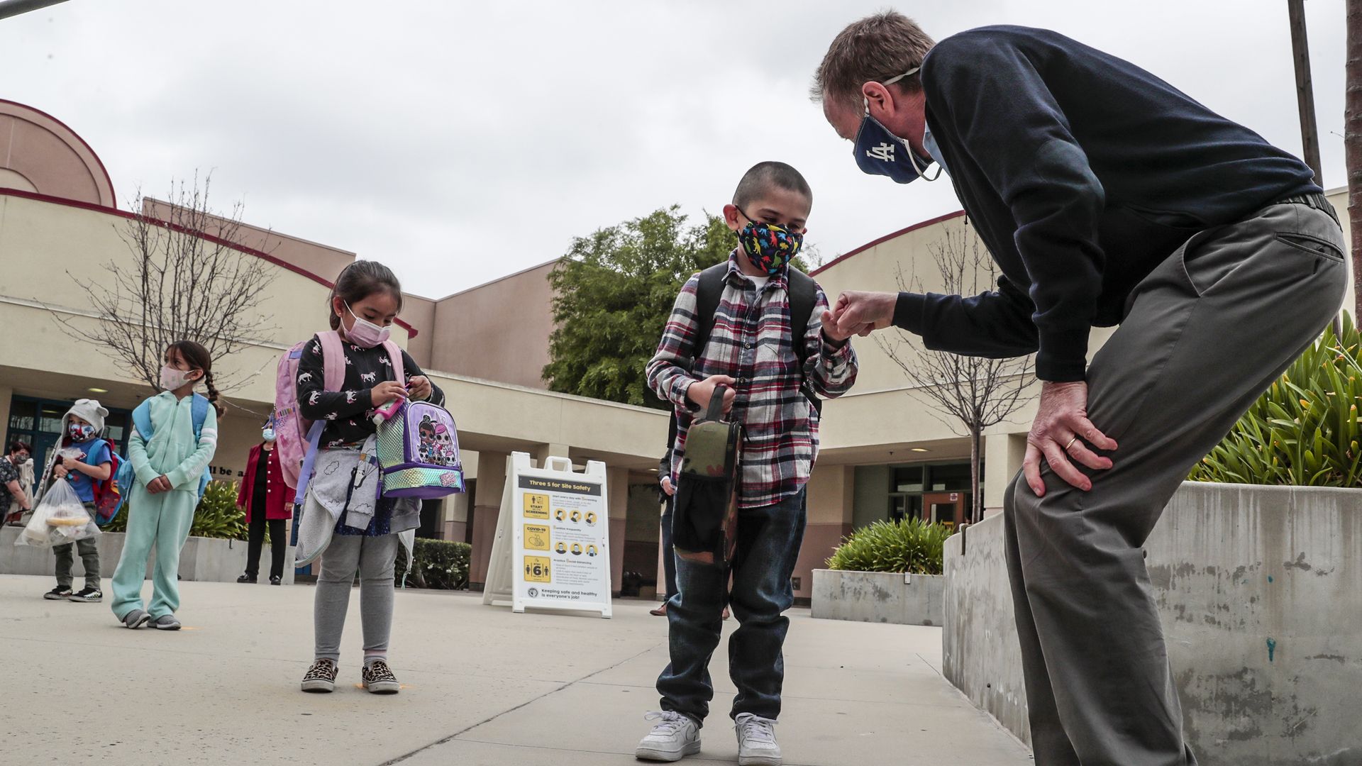 Superintendent Austin Buetner fist bumps Kindergartener as students finish up their first day of school.
