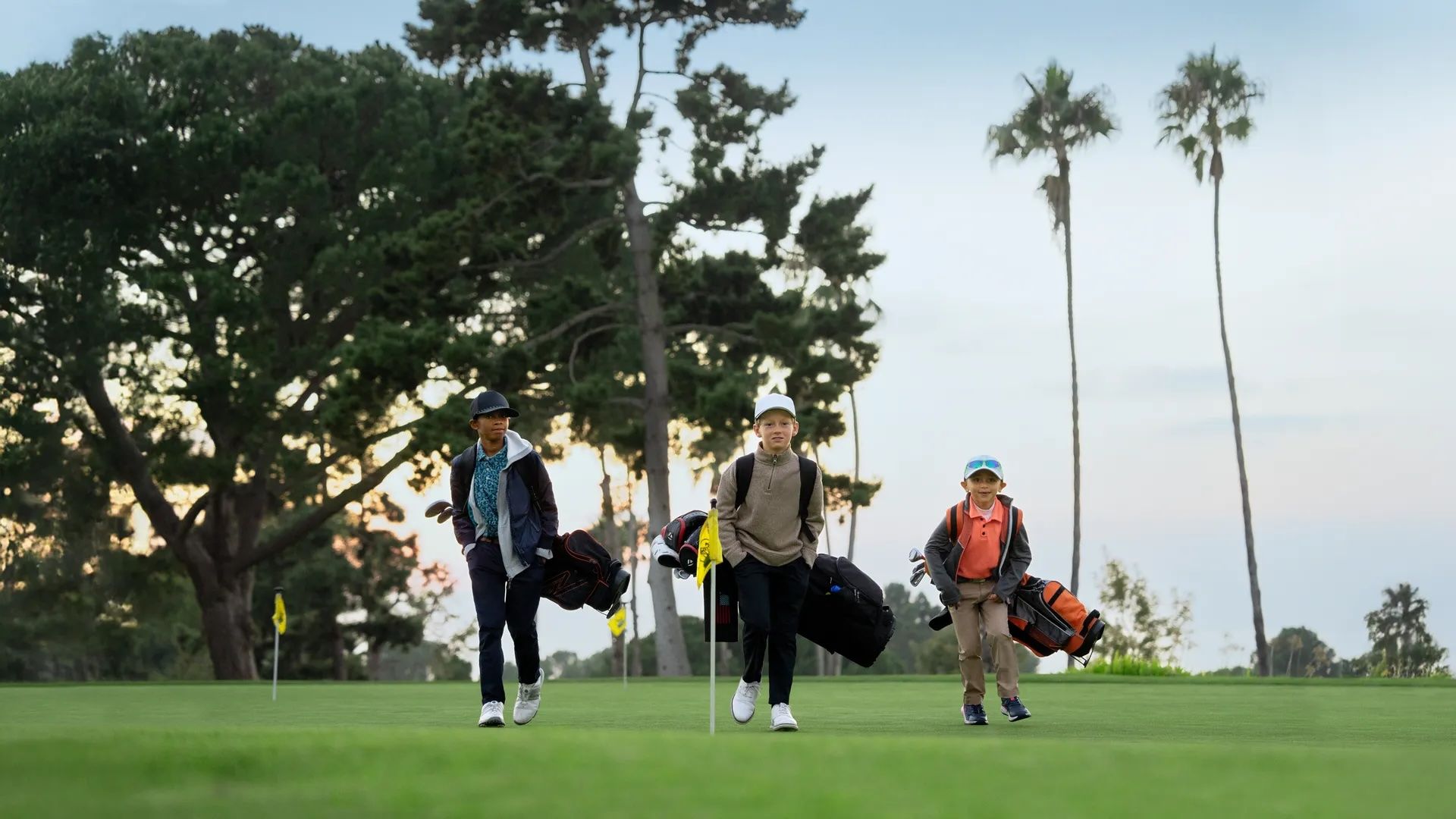 Three children on a golf course. 