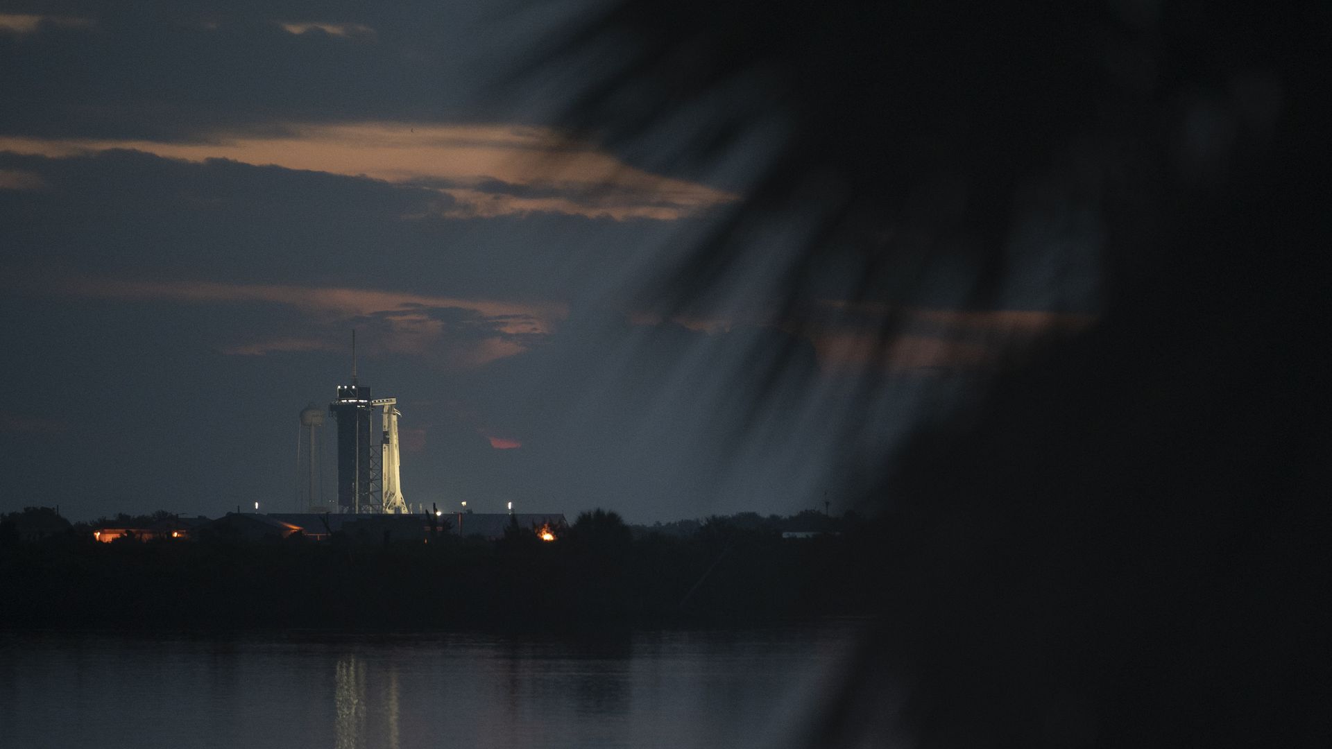 Sunrise on launch day with the Falcon 9 rocket in the distance.