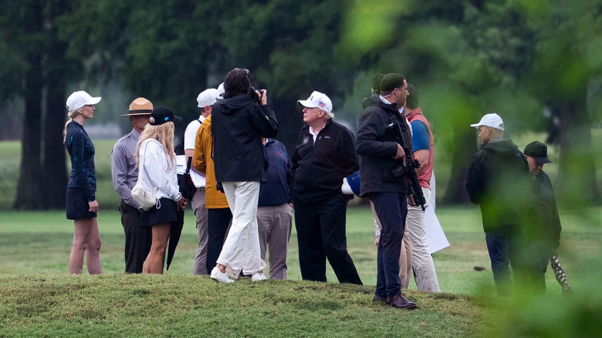 President Trump in the middle of a group of people touring the East Potomac Golf Course