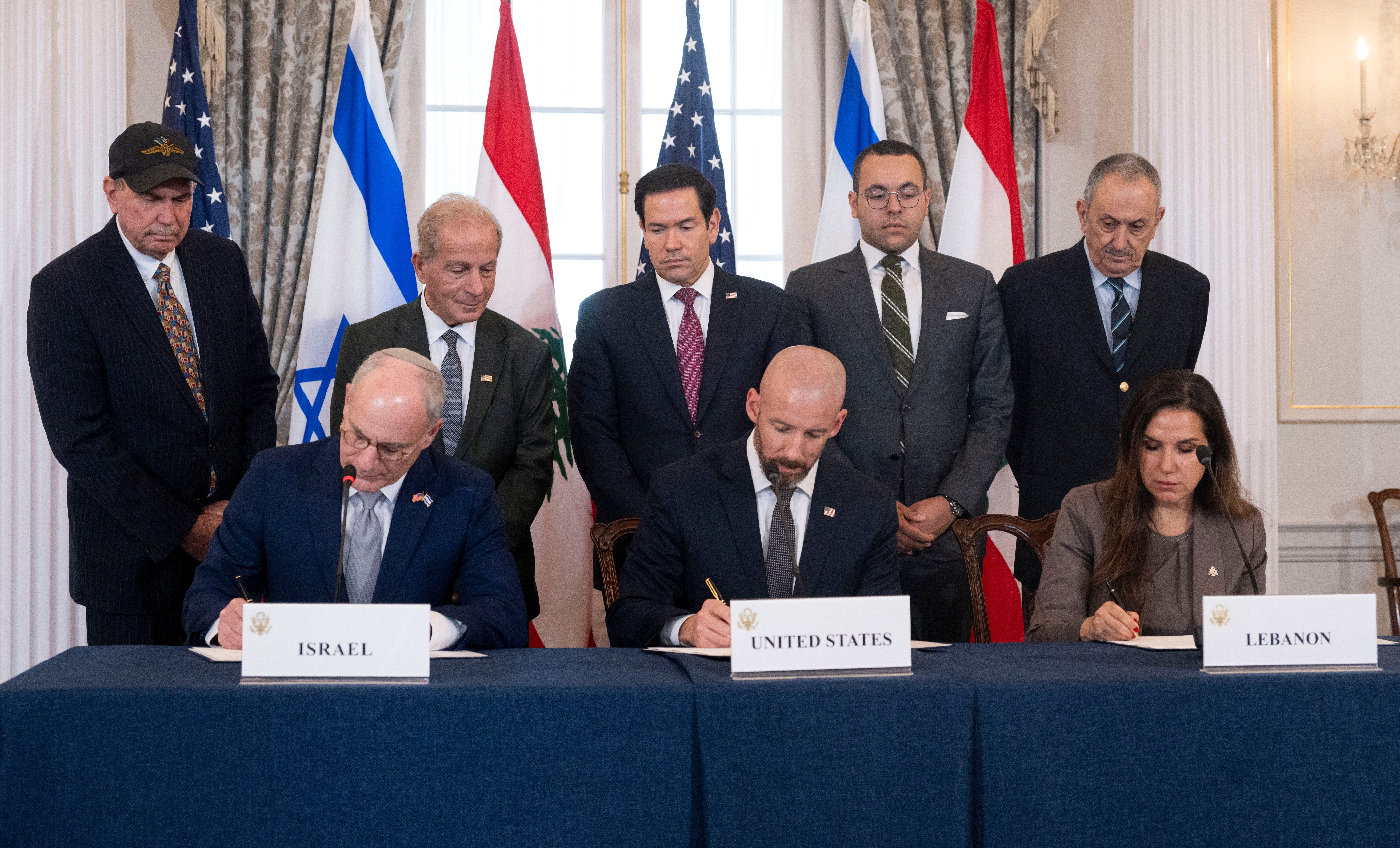 Secretary of State Marco Rubio and others watch, seated from left, Israel's Ambassador to the U.S. Yechiel Leiter, counselor Dan Holler, and Lebanon's Ambassador to the U.S. Nada Hamadeh, sign a framework agreement, described as a first step toward peace following months of conflict between Israel a