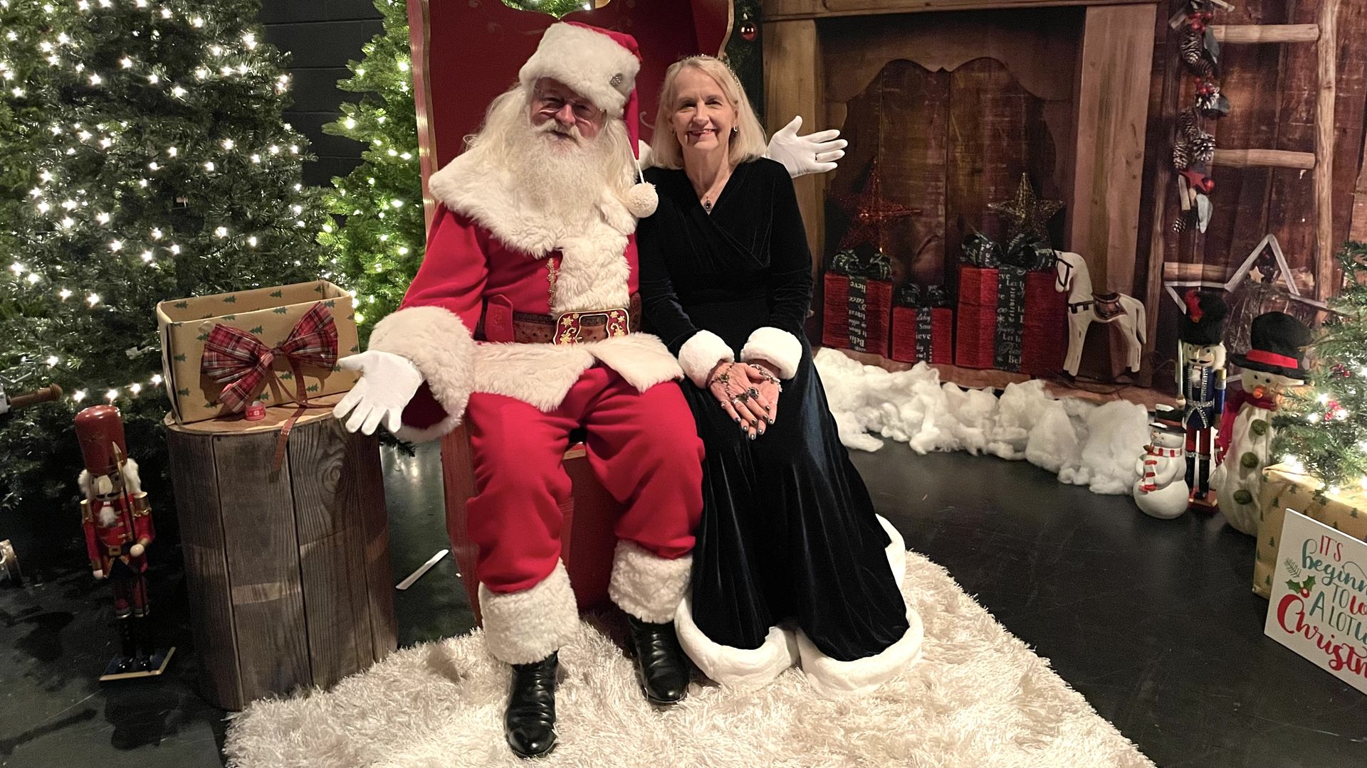 Santa and Mrs. Claus, who is blonde and wearing a dark green velvet gown with fur trim